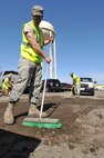 MINOT AIR FORCE BASE, N.D., -- Airman 1st Class Zachary Flowers, 5th Civil Engineer Squadron heavy equipment operator, sweeps excess gravel during a routine road fixture project here May 10. Heavy equipment operators respond to infrastructure emergencies on base, clear roadways, ensure the airfield is clear of debris and holes and keep perimeter roads smooth. (U.S. Air Force photo/Senior Airman Brittany Y. Auld)
