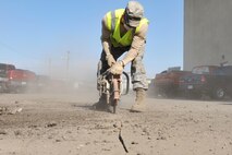 MINOT AIR FORCE BASE, N.D. -- Airman 1st Class Cody Waymire, 5th Civil Engineer Squadron heavy equipment operator, uses a K-12 concrete saw to cut around the damaged concrete during a routine road fixture project here May 10. Heavy equipment operators respond to infrastructure emergencies on base. They clear roadways, ensure the airfield is clear of debris and holes, keep perimeter roads smooth. (U.S. Air Force photo/Senior Airman Brittany Y. Auld)