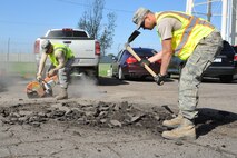 MINOT AIR FORCE BASE, N.D. -- Airman 1st Class Cody Waymire , 5th Civil Engineer Squadron heavy equipment operator, uses a K-12 concrete saw to cut around the damaged concrete while Airman 1st Class Zachary Flowers, 5th CES heavy equipment operator, uses a maddox to break up the concrete during a routine road fixture project here May 10. (U.S. Air Force photo/Senior Airman Brittany Y. Auld)