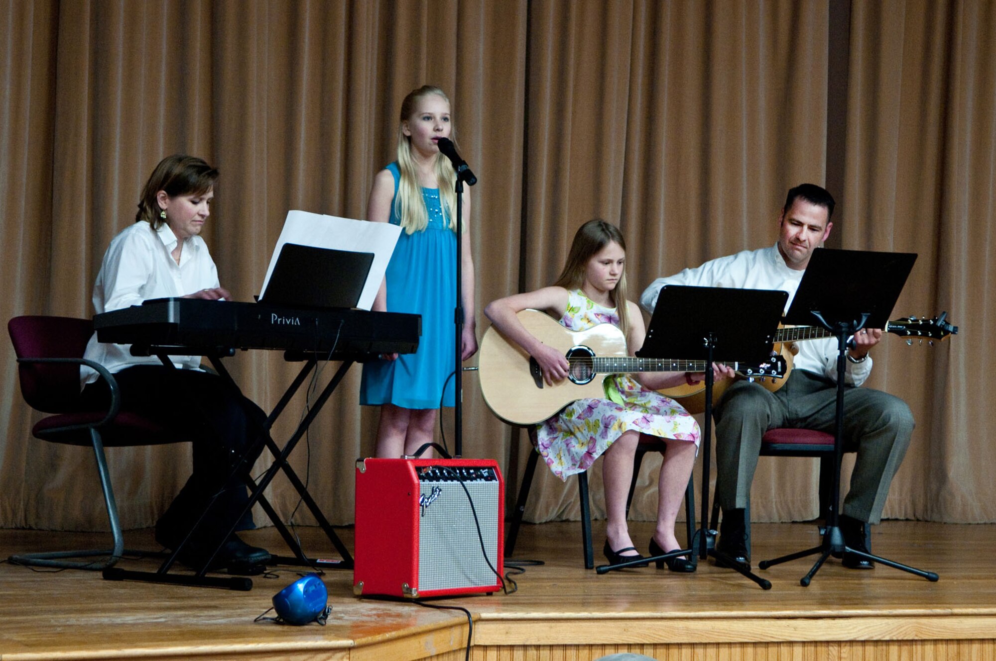 HANSCOM AIR FORCE BASE, Mass. – (left to right) Cathy, Emily, Allison and Matthew McSwain sing "The Children of the Heroes," a song written by Cathy, at the You Got Talent show at the Hanscom Theater May 3. The McSwain family took home the award in the family group act category. (U.S. Air Force photo by Mark Herlihy)