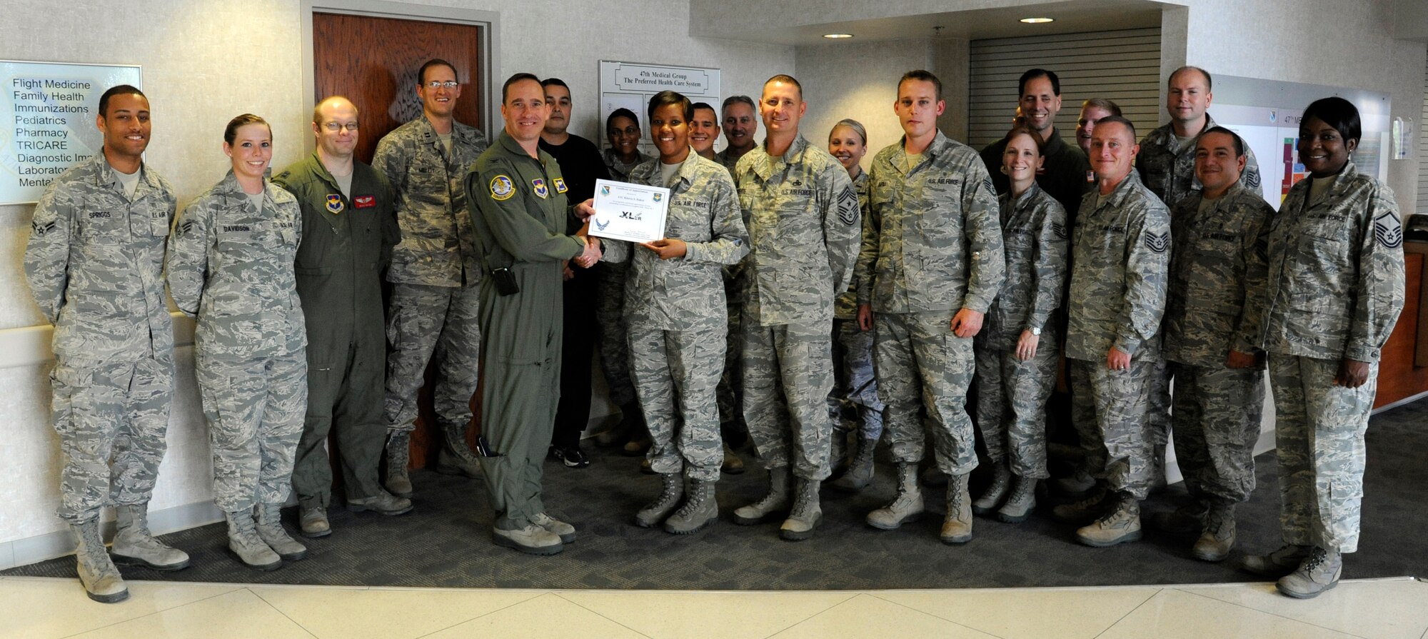 Airman 1st Class Kierra Baker, 47th Medical Operations Squadron family practice medical technician, poses with Col. Tom Murphy, 47th Flying Training Wing commander, and Chief Master Sgt. Ray DeVite, 47th FTW command chief, after being presented the XLer of the week award at Laughlin Air Force Base, Texas, May 9, 2012. The XLer is a weekly award chosen by wing leadership and given to those who consistently make outstanding contributions to Laughlin and their unit. (U.S. Air Force photo/Airman 1st Class Nathan Maysonet)