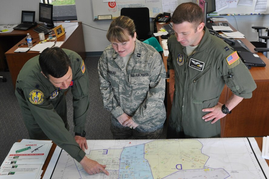 Lt. Col. Thomas "Bart" Elsea, Operational provisional planning officer for the 134AEW, discusses a map of the deployment foreward operating base scheduled to be used for an upcoming deployment exercise for more than 400 Air Force Reservists assigned to the 910th Airlift Wing. Captains Justin Fadem and Angie Serrao are members of the planning team for the 2013 ORI.