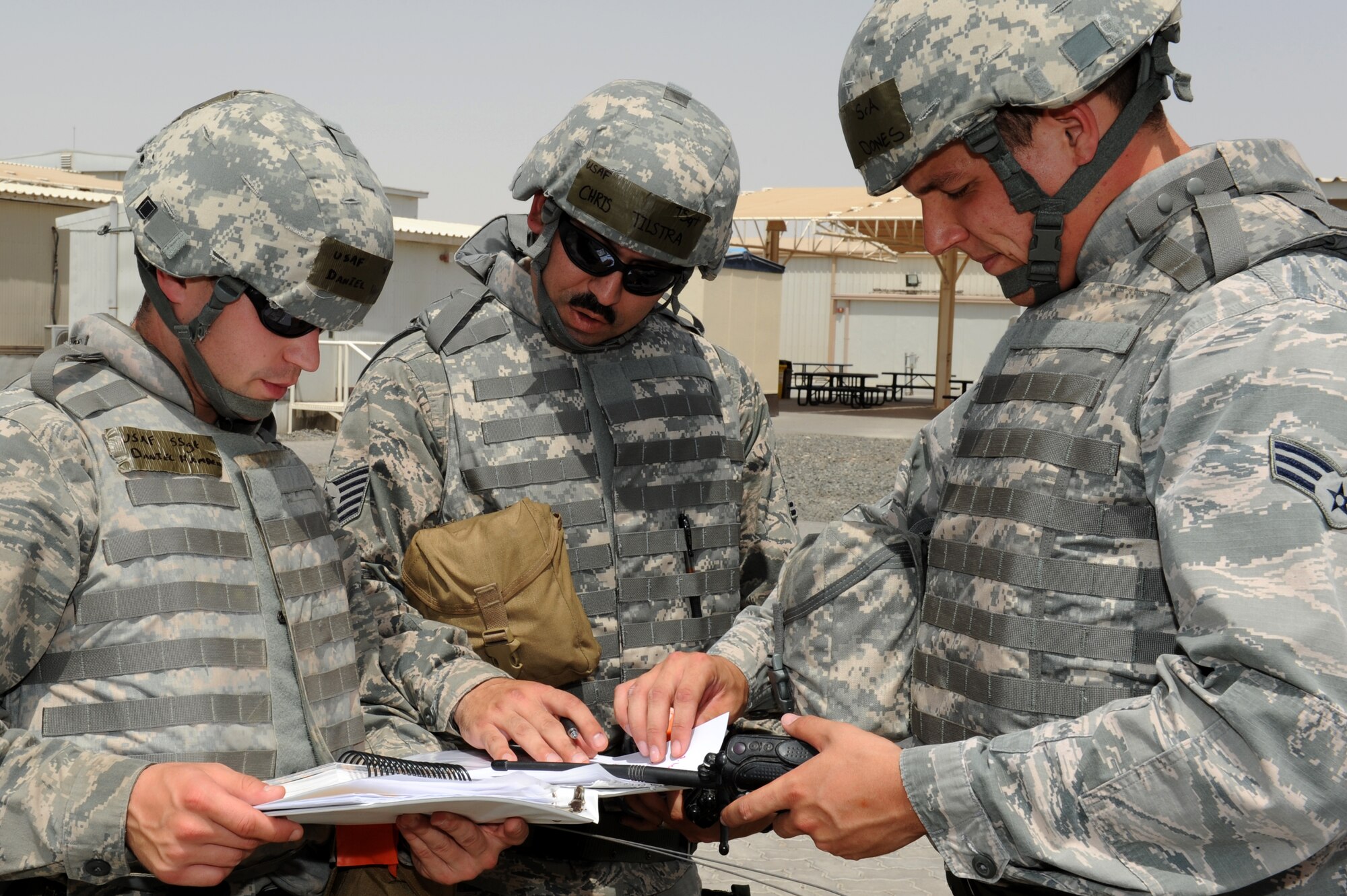 SOUTHWEST ASIA--Staff Sgt. Daniel Hamden, Tech. Sgt. Chris Tilstra and Senior Airman Jon Dones, all from the 380th Expeditionary Civil Engineer Squadron, read a base map in preparation to cordon off an area where a simulated unexploded ordnance was found during an air missile defense exercise at the 380th Air Expeditionary Wing in Southwest Asia May 15, 2012. During the exercise, the wing reaffirmed their readiness in case of a missile attack. (U.S. Air Force photo/Master Sgt. Scott MacKay)