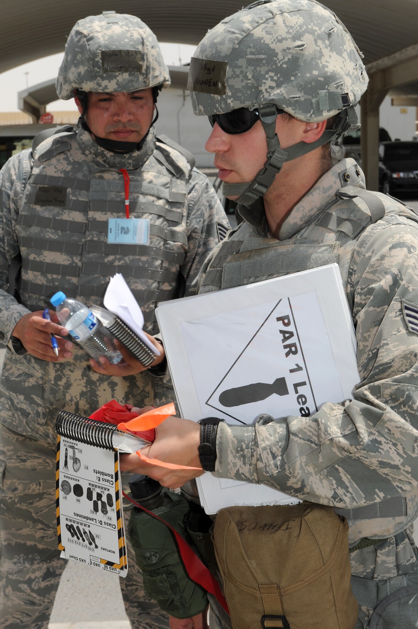 SOUTHWEST ASIA--Staff Sgt. Daniel Hamden from the 380th Expeditionary Civil Engineer Squadron prepares to do an unexploded ordnance sweep as Tech. Sgt. Stephen Payne, an exercise evaluator from the 380th Expeditionary Contracting Squadron, looks on during an air missile defense exercise at the 380th Air Expeditionary Wing in Southwest Asia May 15, 2012. During the exercise, the wing reaffirmed its readiness in case of a missile attack. (U.S. Air Force photo/Master Sgt. Scott MacKay)