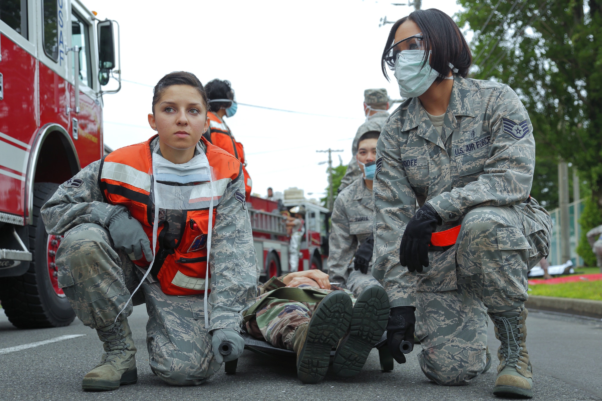 YOKOTA AIR BASE, Japan -- Airman 1st Class Faria Hernandez, left, and Staff Sgt. Jessica Roofe, right, both from the 374th Aerospace Medicine Squadron, prepare to transport a victim with a simulated injury during the Emergency Management Exercise portion of the Consolidated Unit Inspection at Yokota Air Base, Japan, May 15, 2012. Depending on the severity of a patient's injury, they are transported in a variety of ways, to include a four-man litter carry. (U.S. Air Force photo by Osakabe Yasuo)