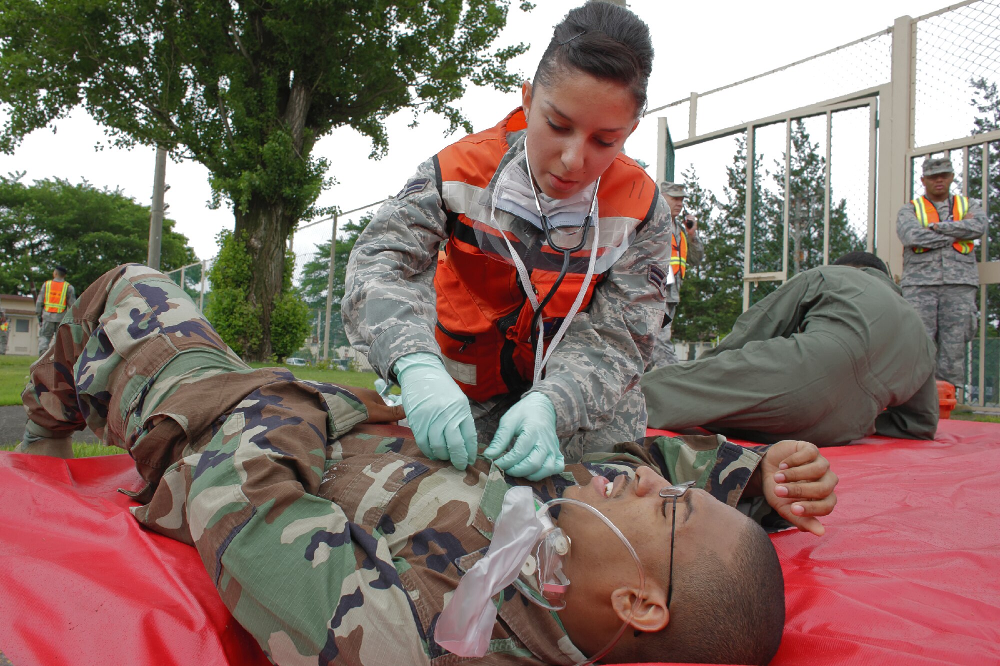 YOKOTA AIR BASE, Japan -- Airman 1st Class Faria Hernandez, 374th Aerospace Medicine Squadron aerospace medical technician, performs self-aid and buddy care to a victim with a simulated injury during the Emergency Management Exercise portion of the Consolidated Unit Inspection at Yokota Air Base, Japan, May 15, 2012. Victims were divided into four categories based on severity of condition minor, delayed, immediate and morgue. (U.S. Air Force photo by Osakabe Yasuo) 