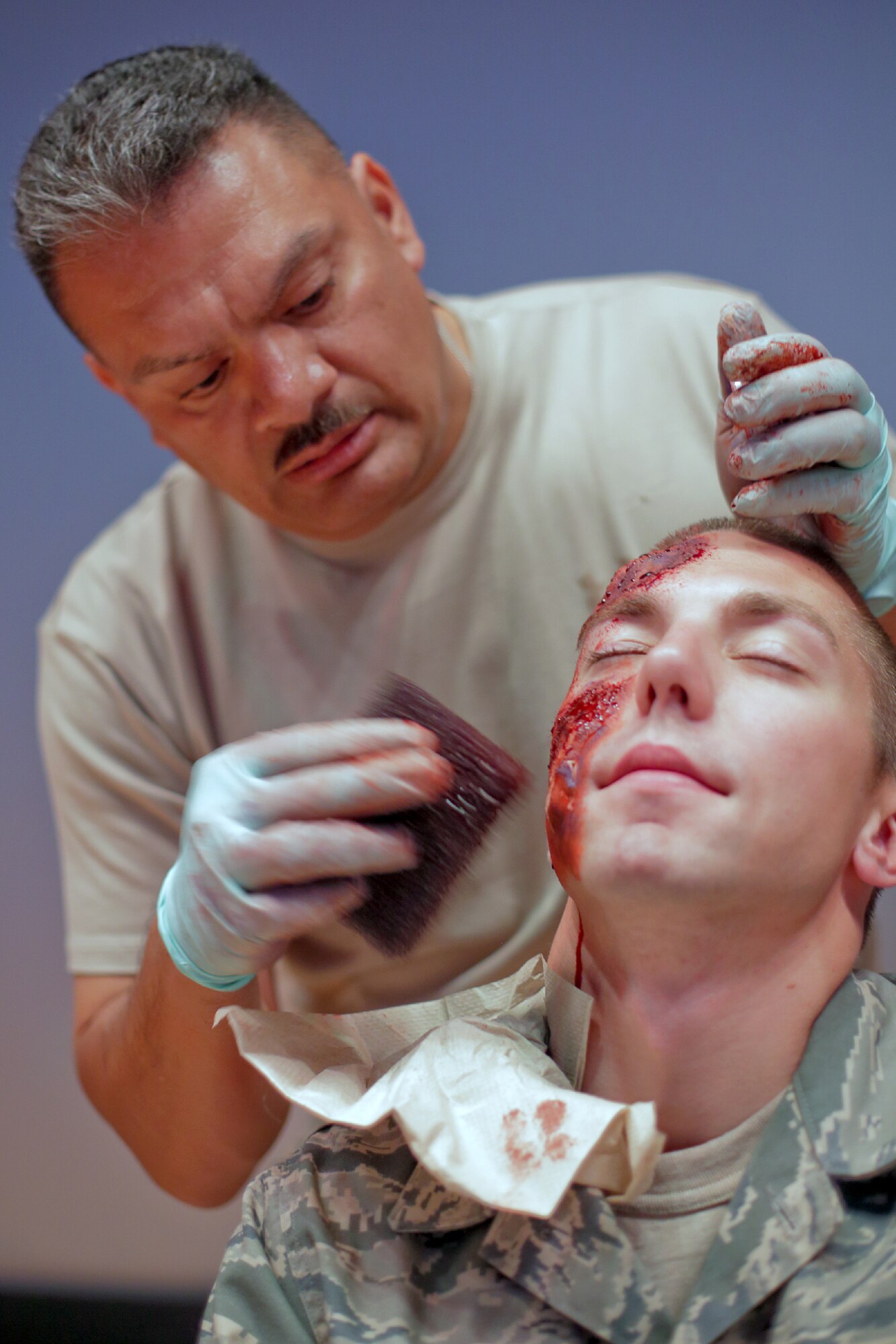 YOKOTA AIR BASE, Japan -- Chief Master Sgt. Rojelio Maritnez, 374th Medical Group, applies moulage makeup to Airman 1st Class Matthew Paine, 374th Aircraft Maintenance Squadron, during the Emergency Medical Exercise portion of the Consolidated Unit Inspection at Yokota Air Base, Japan, May 15, 2012. Moulage provides reality to a simulated patient's injuries for inspections and exercises. (U.S. Air Force photo by Osakabe Yasuo)