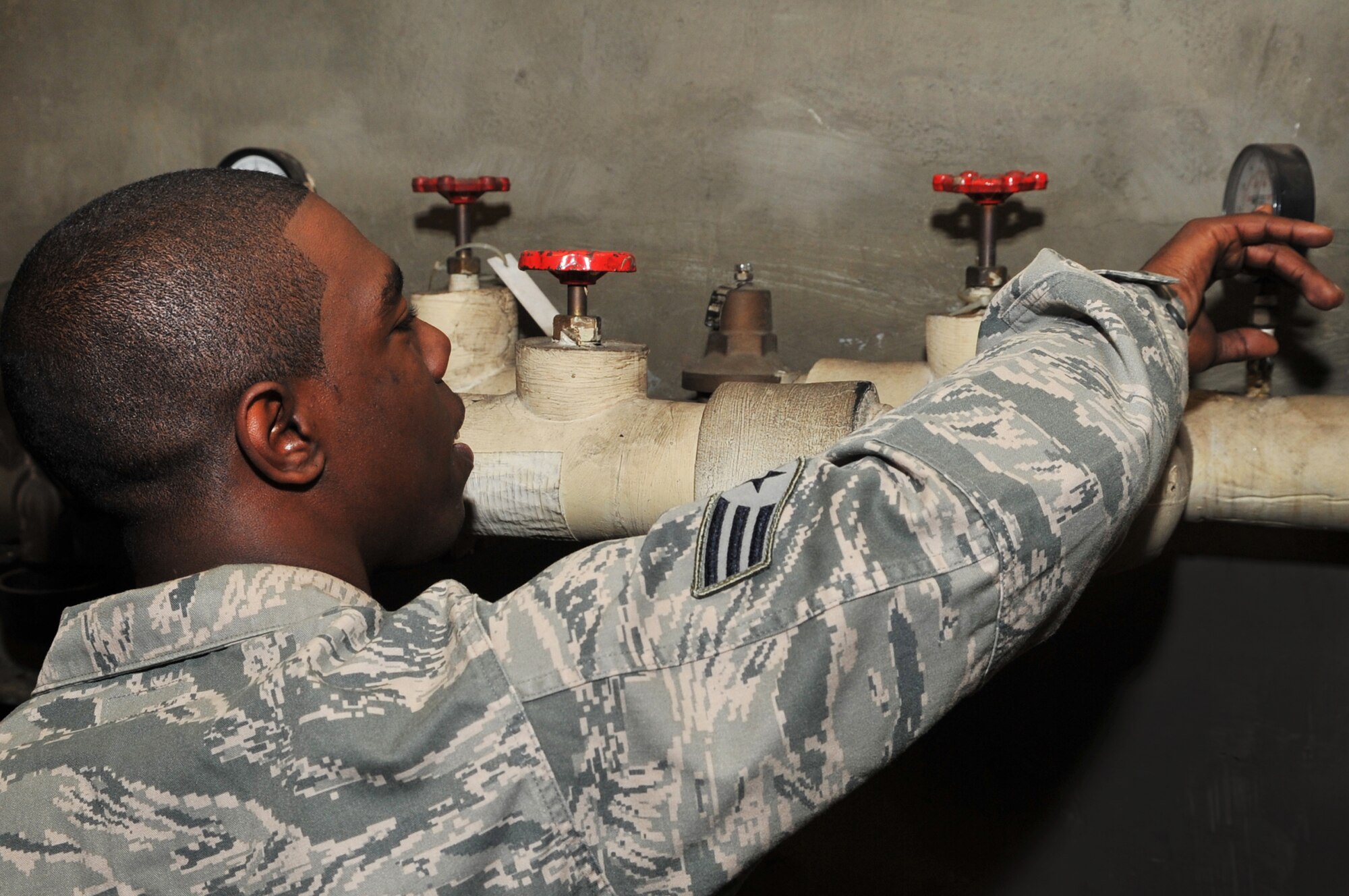 Senior Airman Devin McCree, 51st Civil Engineer Squadron heating, ventilation, and air conditioning technician, verifies the gauge to ensure correct pressure is achieved at Osan Air Base, Republic of Korea, May 16, 2012. The HVAC shop has started to prepare air conditioning units, for Korea’s summer heat. (U.S. Air Force photo/Staff Sgt. Craig Cisek)