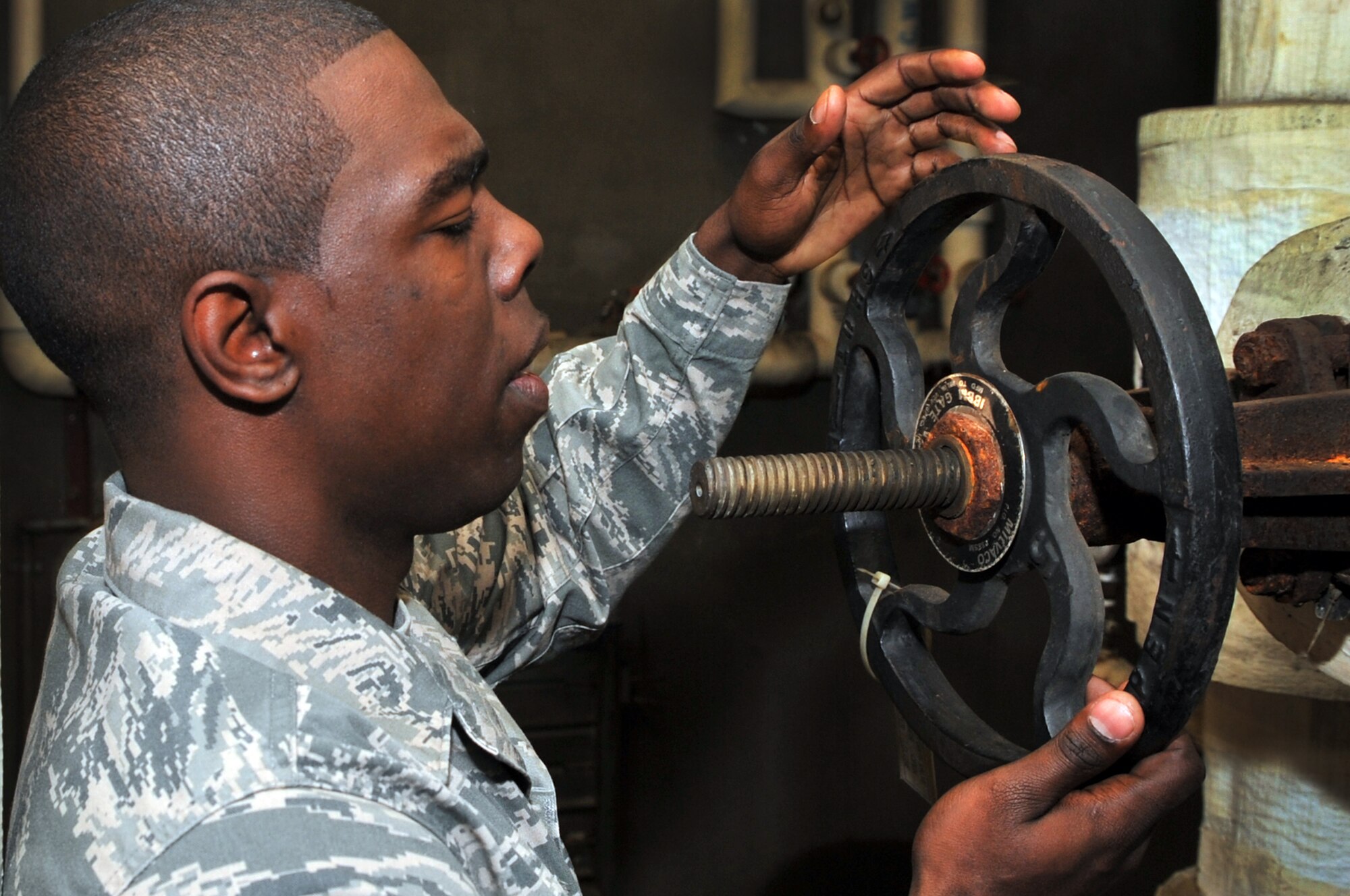 Senior Airman Devin McCree, 51st Civil Engineer Squadron heating, ventilation, and air conditioning technician, opens up the building return valve to a water pump at Osan Air Base, Republic of Korea, May 16, 2012. The HVAC shop is preparing air conditioning units, for Korea’s summer heat. (U.S. Air Force photo/Staff Sgt. Craig Cisek)