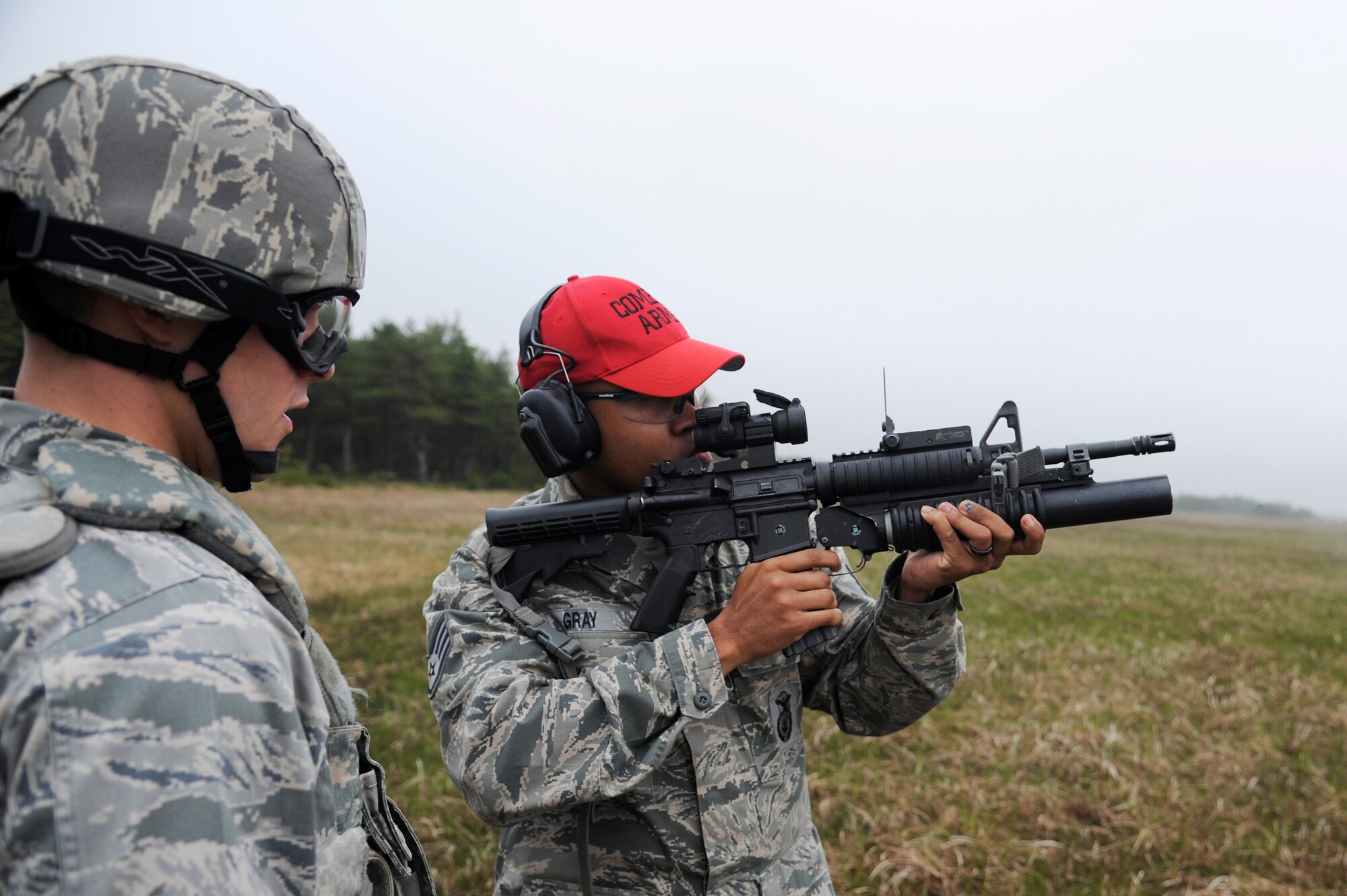 U.S. Air Force 2nd Lt. Harlan Glinski, left, 35th Security Forces Squadron logistics and resources officer, watches as Staff Sgt. Quentin Gray, 35 SFS combat arms instructor, demonstrates how to hold and fire a M203 grenade launcher during qualification training at Draughon Range, Japan, May 16, 2012. The M203 grenade launcher is a single-shot weapon designed for use with the M16 series rifle and M4 series carbine and has an effective range of approximately 400 meters. (U.S. Air Force photo by Tech. Sgt. Marie Brown/Released)
