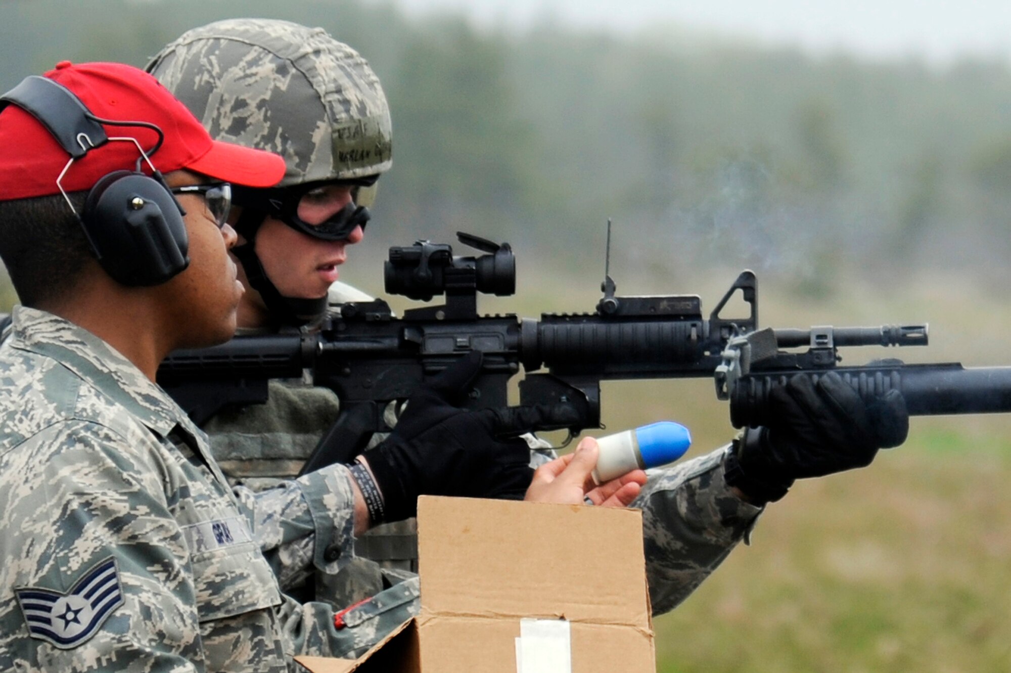 U.S. Air Force Staff Sgt. Quentin Gray, left, 35th Security Forces Squadron combat arms instructor, loads a 40mm practice round into a M203 grenade launcher for 2nd Lt. Harlan Glinski, 35 SFS logistics and resources officer, during qualification training at Draughon Range, Japan, May 16, 2012. Security Forces Airmen must stay proficient and maintain their deployment status at all times, as well as, qualify annually on weapons they have been trained to fire. (U.S. Air Force photo by Tech. Sgt. Marie Brown/Released) 

