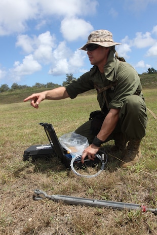 Sgt. Joseph R. Pacheco, Marine Wing Support Squadron 171 expeditionary airfield technician, surveys the land to set up the arresting gear which will help stop the aircraft in case of emergencies and further training exercises during Exercise Geiger Fury 2012. The arresting gear is an absolute necessity before aircraft can land on the airfields of Tinian.
