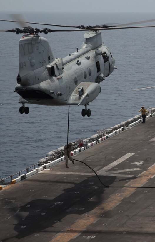 A Marine with Company I descends down a thick, plaited rope rigged to a CH-46E Sea Knight flown by pilots with Marine Medium Helicopter Squadron 268 (Reinforced) onto USS Makin Island's flight deck here May 16. The company is one of three rifle companies in Battalion Landing Team 3/1, the ground combat element for the 11th Marine Expeditionary Unit. The unit embarked the ship, as well as USS New Orleans and USS Pearl Harbor in San Diego Nov. 14, beginning a seven-month deployment to the Western Pacific, Horn of Africa and Middle East regions.