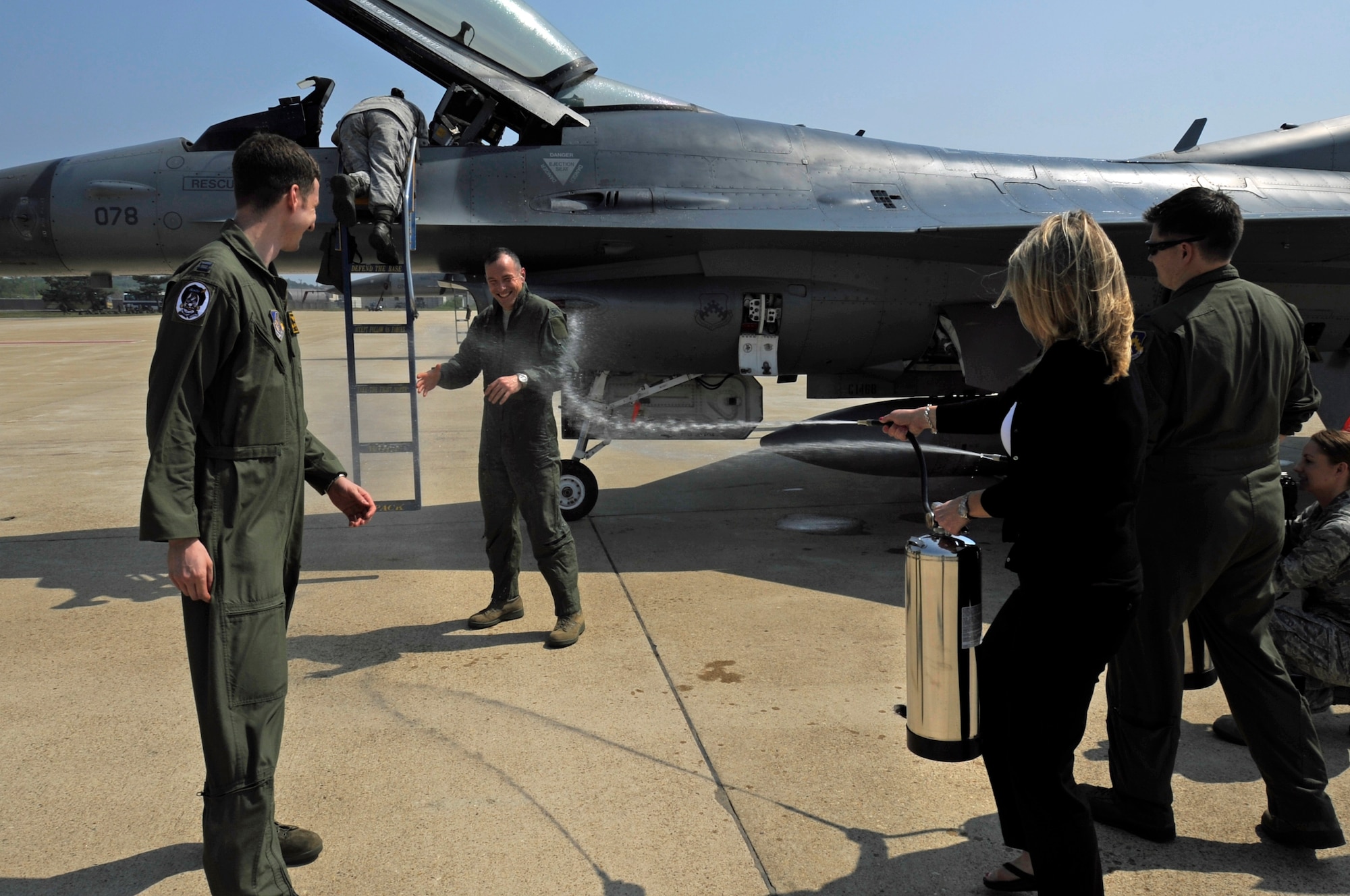 Col. Scott L. Pleus, 8th Fighter Wing commander, is sprayed with water by his wife, Jennifer Pleus, after his final flight as the wing commander of the Wolf Pack on Kunsan Air Base, Republic of Korea, May 16, 2012. (U.S. Air Force photo/Senior Airman Jessica Hines)