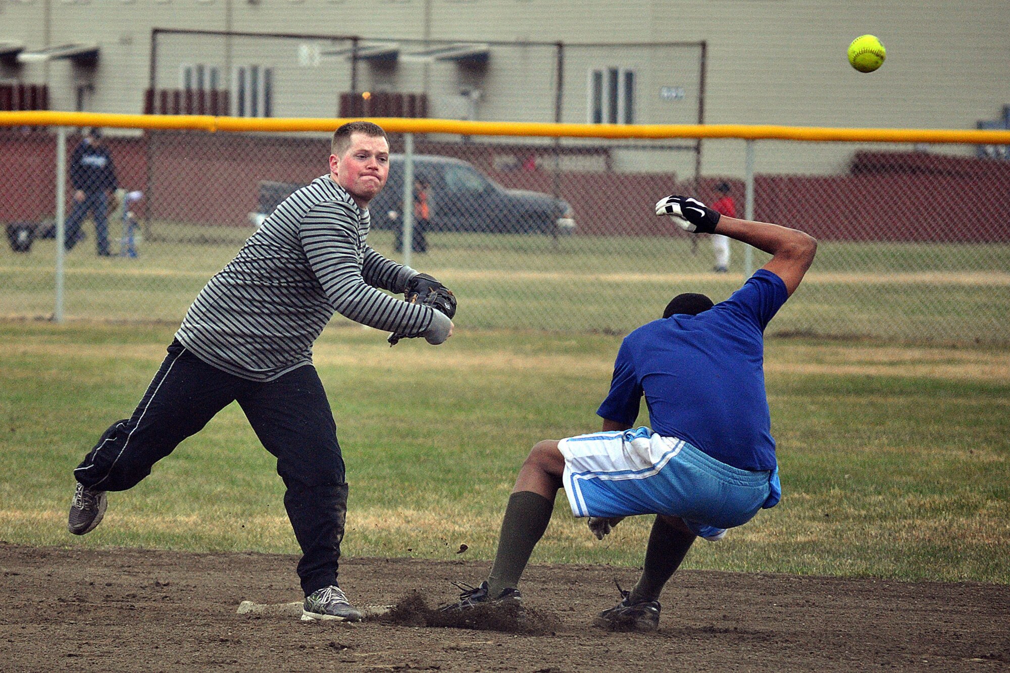 Taylor Berry, 98th Maintenance Company second baseman, makes the turn to complete a 6-5-3 double play in the second championship game. Berry and his 98th Maintenance Company teammates scored 70 runs in their final three games to come from the loser?s bracket and win the JBER-Richardson pre-season softball tournament Saturday at Buckner Physical Fitness Center. (U.S. Air Force photos/John Pennell)
