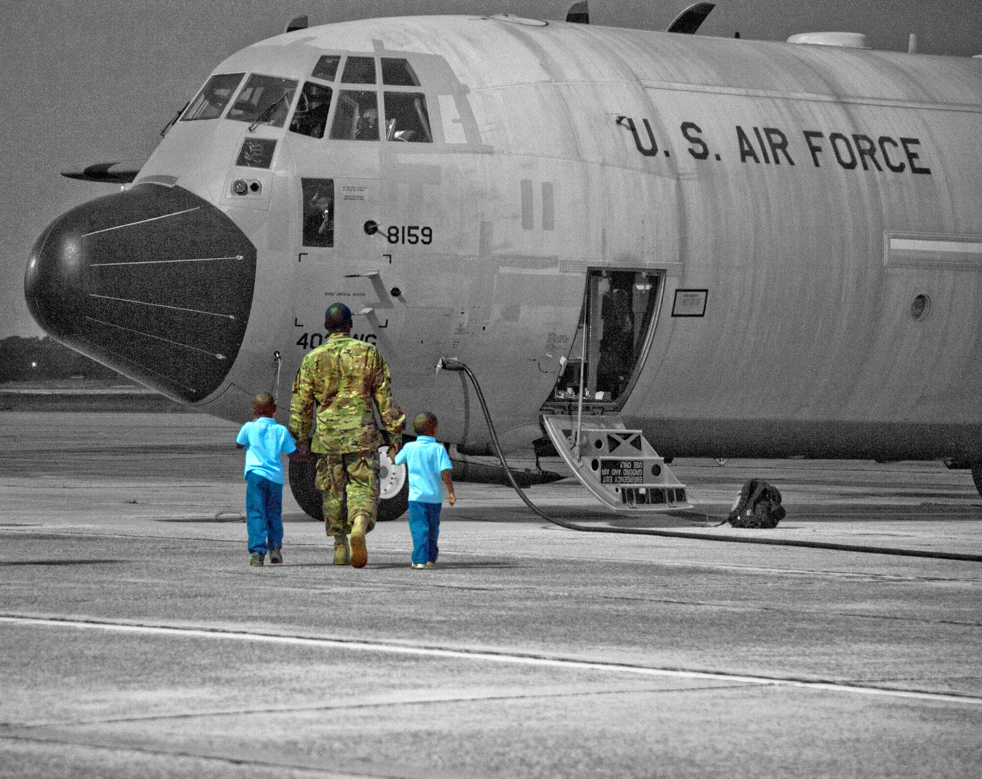 Senior Airman Deonte Spann, 345th Maintenance, walks his two oldest sons, Deon and Catrell, out to see the C-130J aircraft he will board for deployment to Southwest Asia. (U.S. Air Force illustration by Maj. Heather Newcomb)