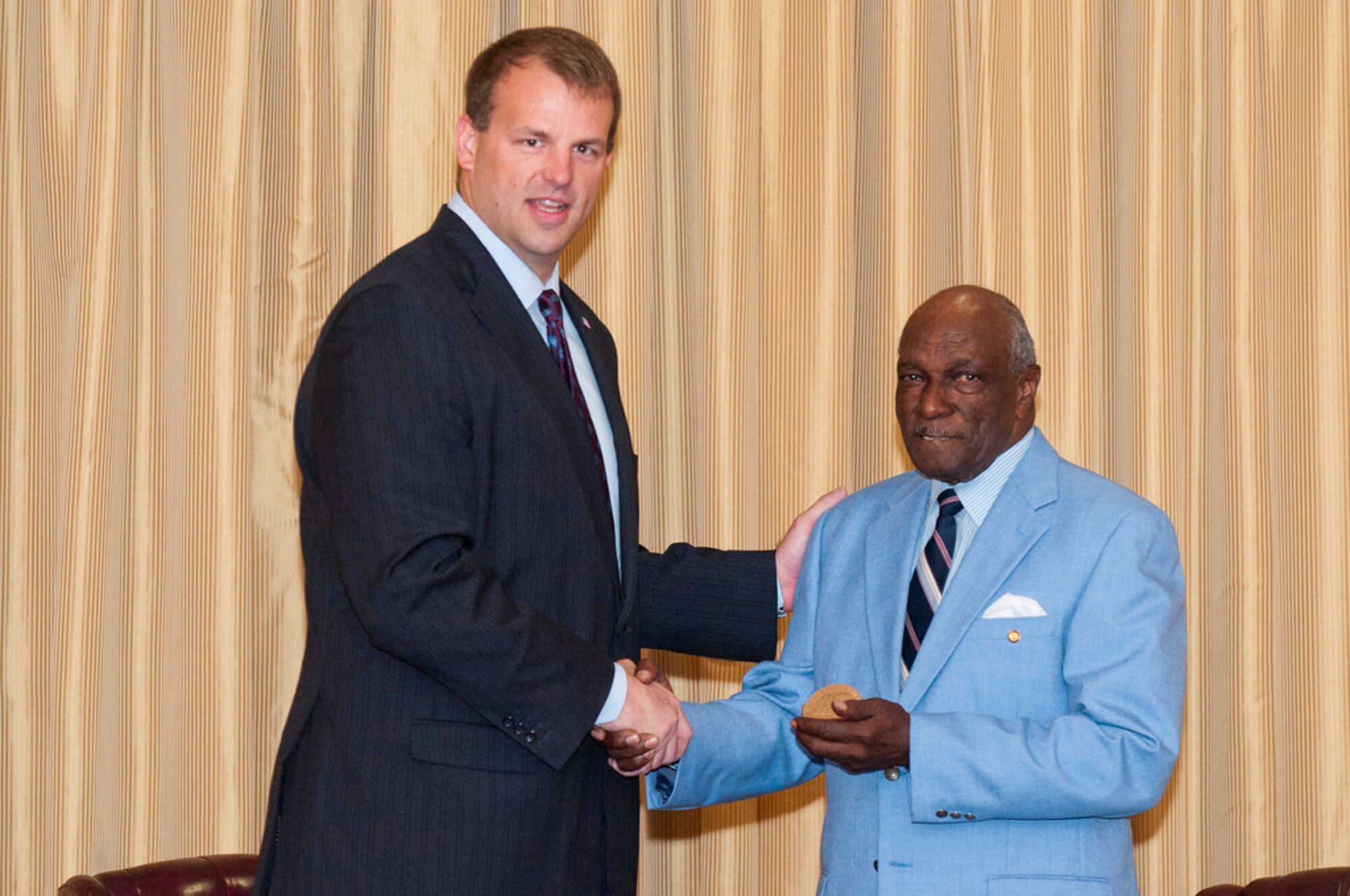 Congressman Jon Runyan, N.J. 3rd Congressional District, presents retired Chief Master Sgt. James A. Cotten a replica of the Congressional Gold Medal awarded to the Tuskegee Airmen in 2007 by President George W. Bush May 3 here. Cotten was drafted into the U.S. Army Aug. 14, 1945, and upon completion of basic training in January 1946, he was selected for assignment to the famed Tuskegee Airmen 332nd Fighter Group, the all African-American Army Air Corps Unit. (U.S. Air Force photo by Wayne Russell/Released)