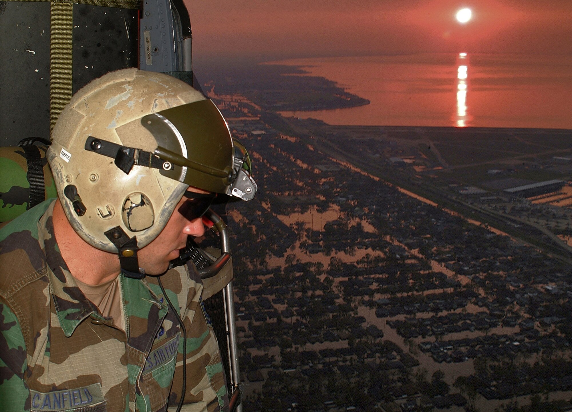 NEW ORLEANS – Scanning for signs of survivors, Tech. Sgt. Andrew Canfield keeps a close watch as the sun sets on the flooded city of New Orleans on Sept. 4, 2005. A provision of the 2012 National Defense Authorization Act permits the federal government to mobilize Air Force reservists like Canfield if they are needed to respond to natural disasters such as Hurricane Katrina. (U.S. Air Force photo/Master Sgt. Bill Huntington)