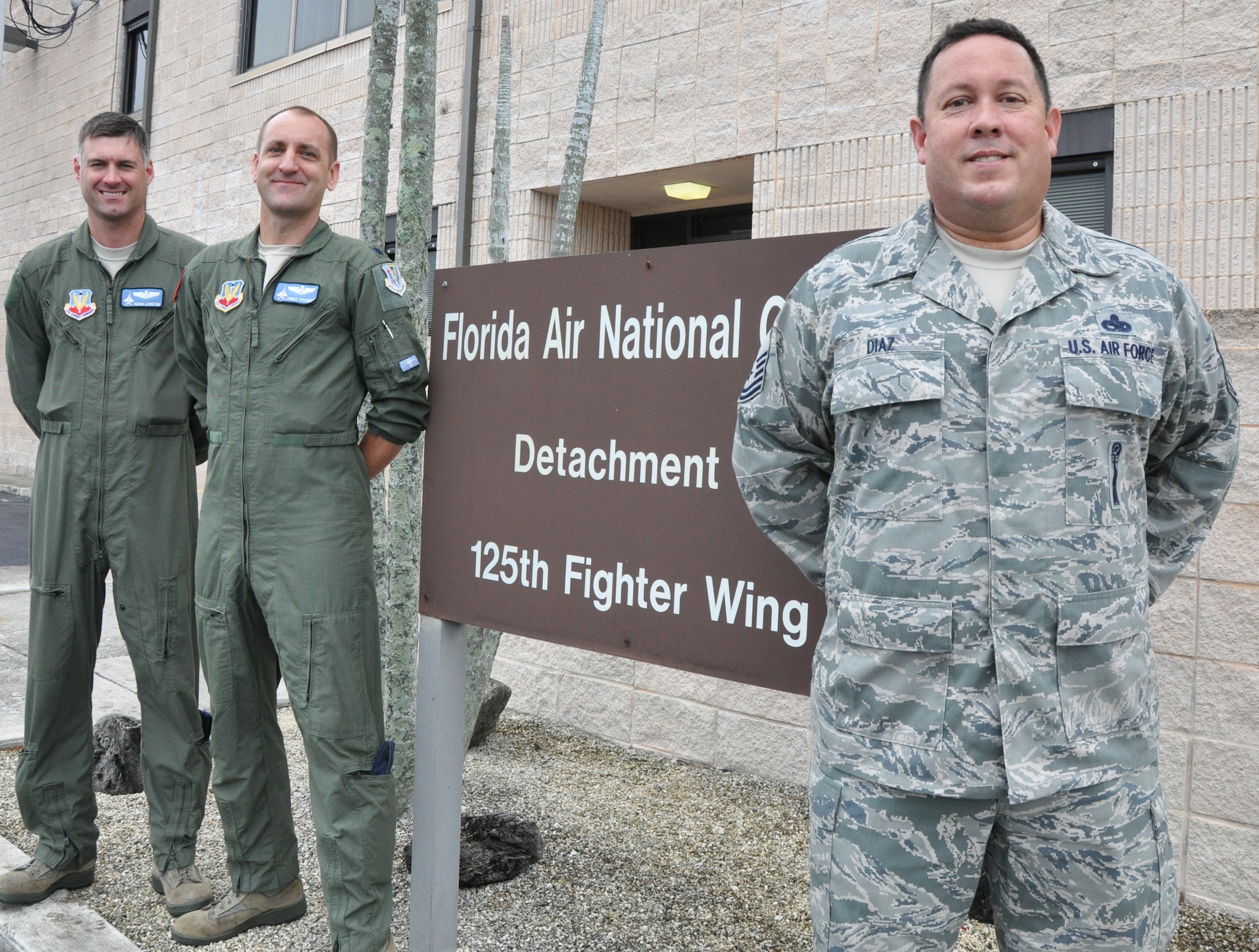 Leadership from the Florida Air National Guard's Det. 1, 25th Fighter Wing, based at Homestead Air Reserve Base in South Florida pose outside of their unit headquarters after their team helped score a "Mission Ready" rating on a recent NORAD inspection. Pictured are Maj. Adam Langton (left), Commander Lt. Col. James Spooner, and Chief Enlisted Manager Senior Master Sgt. Eddie Diaz. Photo by Master Sgt. Thomas Kielbasa