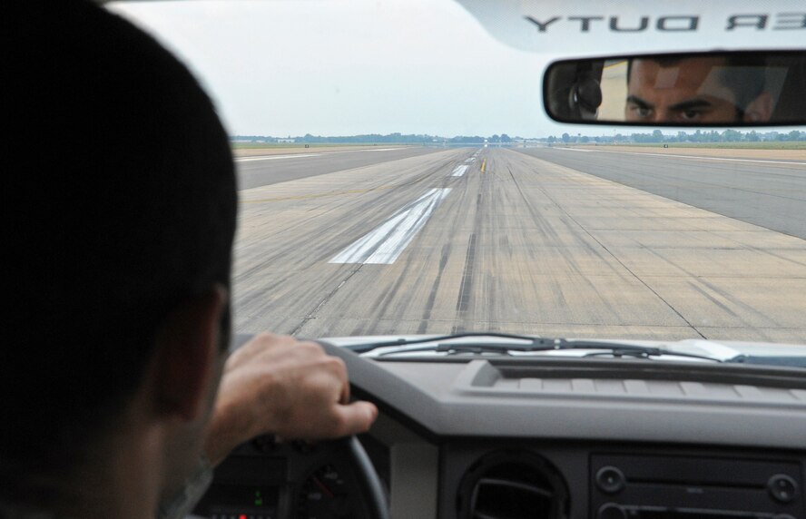 Airman 1st Class Mario Carfagno III, 2nd Operations Support Squadron airfield manager, searches the runway for spalls and other potential hazards on Barksdale Air Force Base, La., May 15. Spalling is when a part of the runway breaks and creates holes or gaps, spreading debris across the runway. (U.S. Air Force photo/Airman 1st Class Micaiah Anthony)(RELEASED)