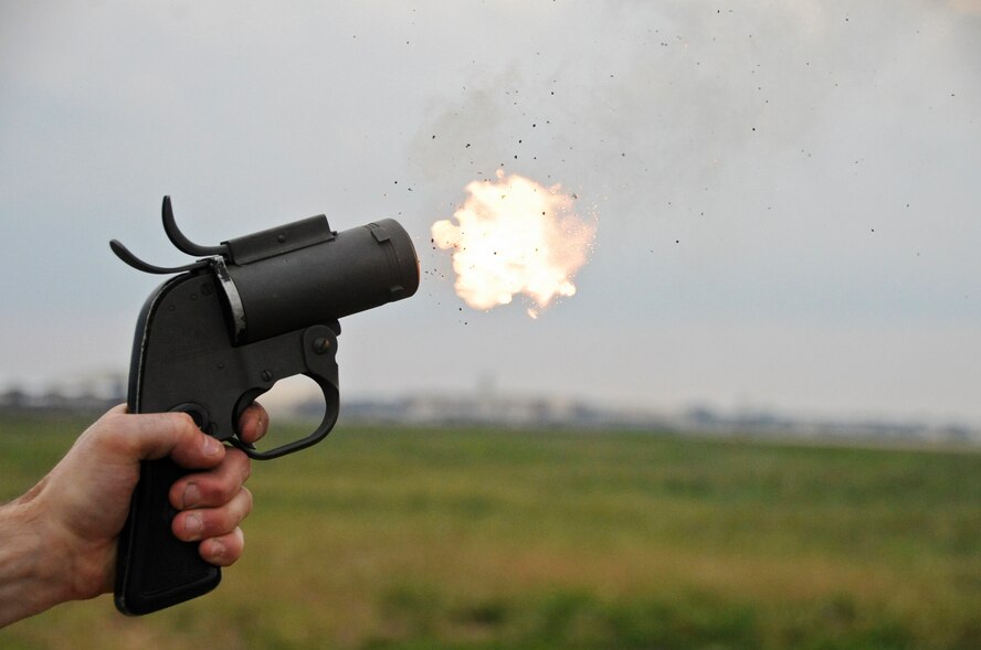 Airman 1st Class Mario Carfagno III, 2nd Operations Support Squadron airfield manager, fires a 12-gauge pyrotechnics pistol on Barksdale Air Force Base, La., May 15. The 12-gauge pistol launches a projectile that creates a small explosion near its desired target causing minimal collateral damage. The pistol is a non-lethal option for airfield managers to choose from when scaring birds away from the flightline. (U.S. Air Force photo/Airman 1st Class Micaiah Anthony)(RELEASED)
