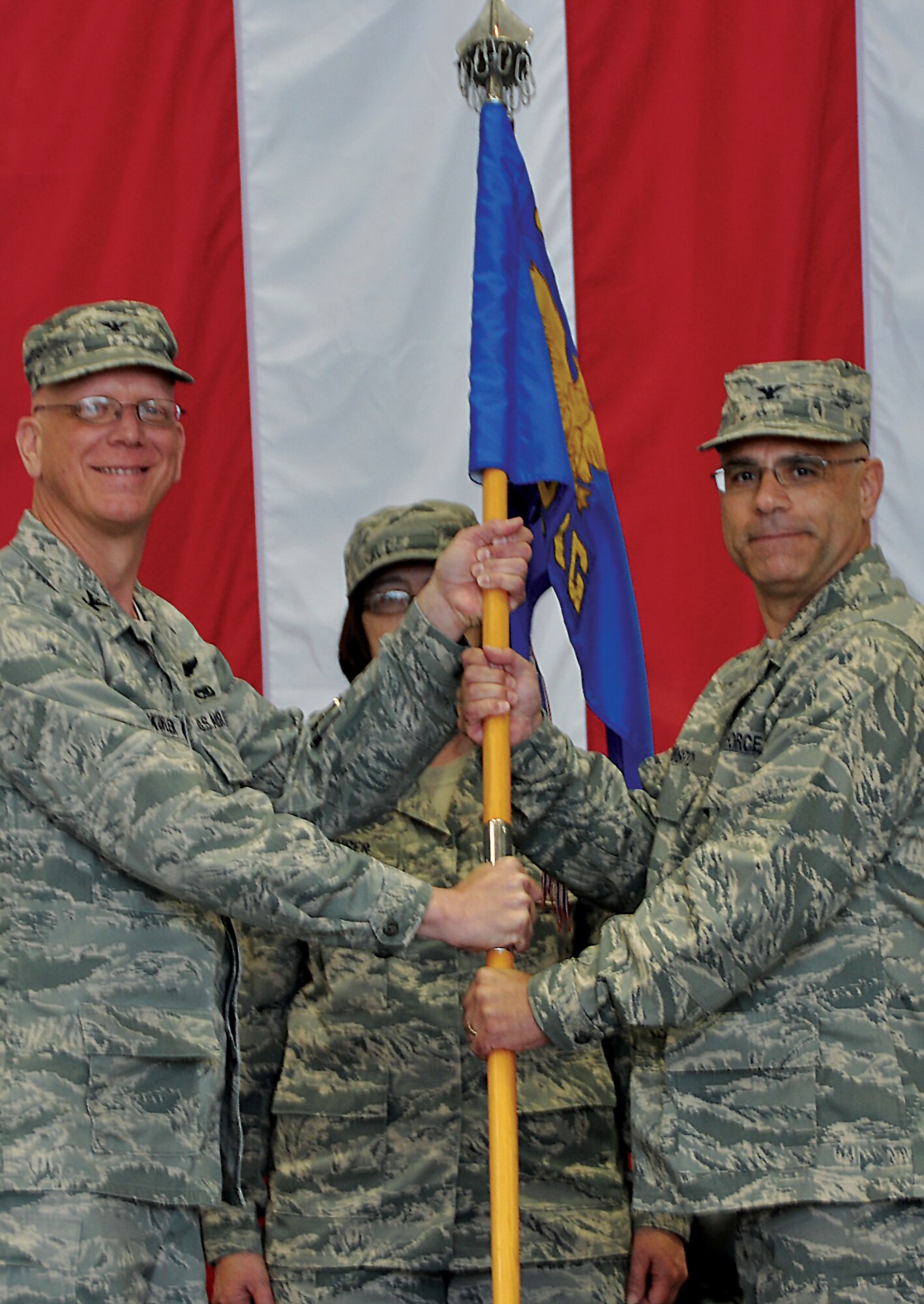 Col. Michael Underkofler (left), 514th Air Mobility Wing commander, passes the 514th Maintenance Group guidon to Col. Anthony Esposito during the change-of-command ceremony in which Esposito became the group’s commander May 5. Chief Master Sgt. Linda Menser, the group superintendent stands behind the colonels. Esposito, who is formerly an enlisted Airman, was commissioned through the deserving Airman program at the Freedom Wing in 1990. He served in various maintenance positions here until 2007, when he left for a position with the 4th Air Force. He retired from the New York Police Department, where he served as an aircraft maintenance supervisor. (U.S. Air Force photo by Tech. Sgt. Jonathan E. White)