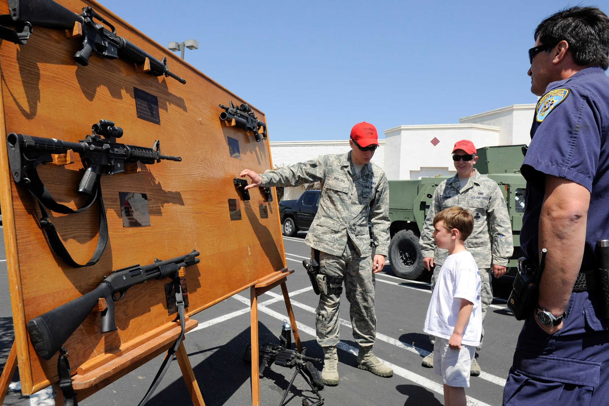 VANDENBERG AIR FORCE BASE, Calif. -- 30th Security Forces Squadron combat arms instructors talk to a local child about weapons used by the U.S. Air Force during a police display event at the Albertsons parking lot in Lompoc, Wednesday, May 16th, 2012. The display was held in conjunction with National Police Week, an annual celebration that recognizes the service and sacrifice of U.S. law enforcement personnel. (U.S. Air Force photo/Staff Sgt. Levi Riendeau)