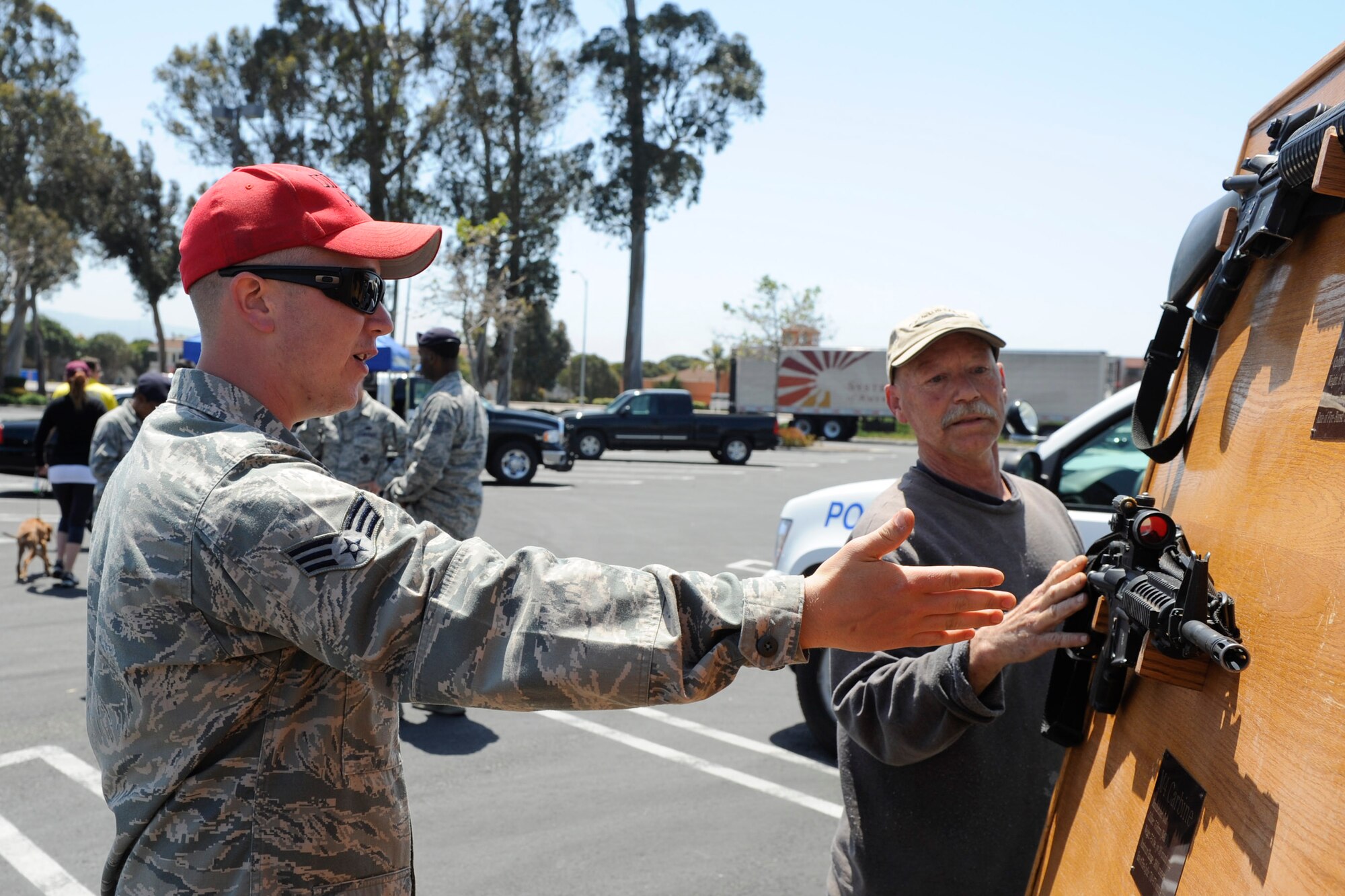 VANDENBERG AIR FORCE BASE, Calif. -- Senior Airman Nathan Lowman, 30th Security Forces Squadron combat arms instructor, talks to a local man about the M4 Carbine used by the U.S. Air Force during a police display event at the Albertsons parking lot in Lompoc, Wednesday, May 16th, 2012. The display was held in conjunction with National Police Week, an annual celebration that recognizes the service and sacrifice of U.S. law enforcement personnel. (U.S. Air Force photo/Staff Sgt. Levi Riendeau)
