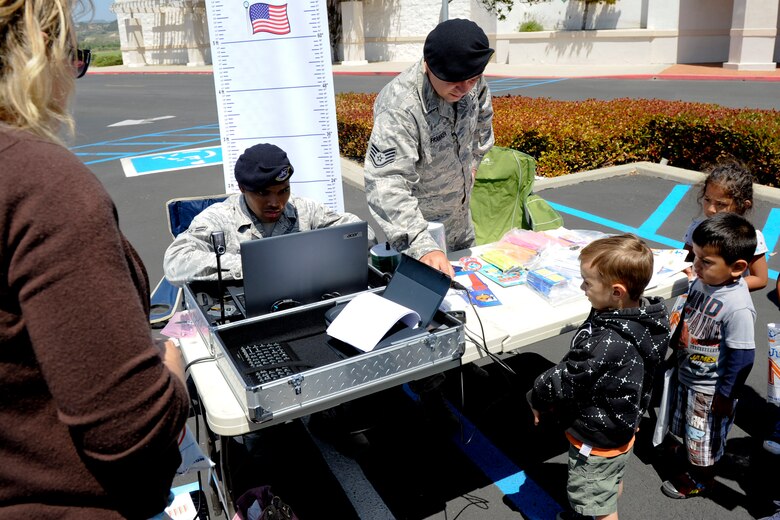 VANDENBERG AIR FORCE BASE, Calif. -- Members of the 30th Security Forces Squadron fingerprint and interview local children during a police display event at the Albertsons parking lot in Lompoc, Wednesday, May 16th, 2012. The display was held in conjunction with National Police Week, an annual celebration that recognizes the service and sacrifice of U.S. law enforcement personnel. (U.S. Air Force photo/Staff Sgt. Levi Riendeau)