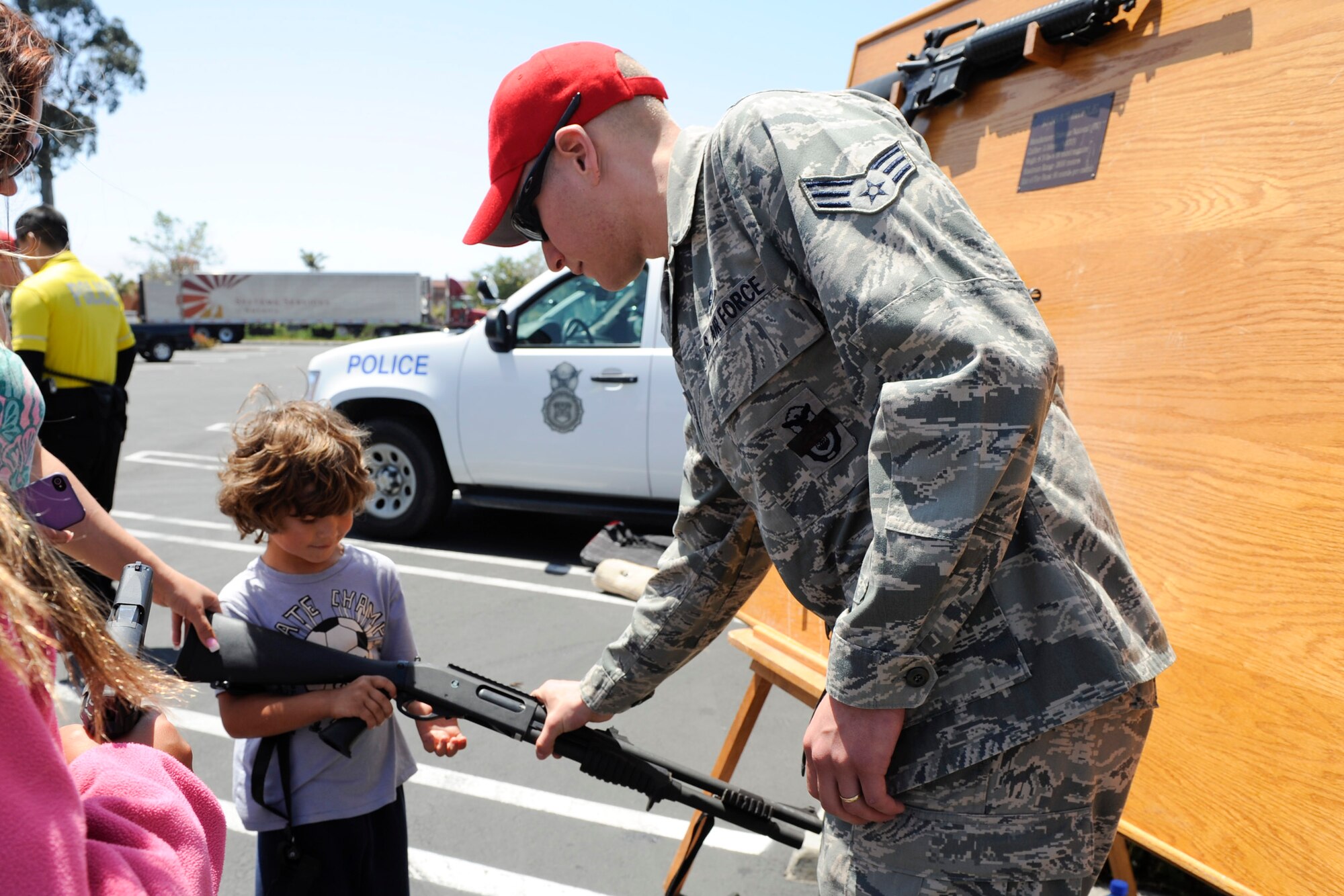 VANDENBERG AIR FORCE BASE, Calif. -- Senior Airman Nathan Lowman, a 30th Security Forces Squadron combat arms instructor, shows a local boy a pistol used by the U.S. Air Force during a police display event at the Albertsons parking lot in Lompoc, Wednesday, May 16th, 2012. The display was held in conjunction with National Police Week, an annual celebration that recognizes the service and sacrifice of U.S. law enforcement personnel. (U.S. Air Force photo/Staff Sgt. Levi Riendeau)