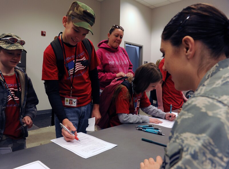 WHITEMAN AIR FORCE BASE, Mo. -- Airman 1st Class Stephanie Tornero, 509th Force Support Squadron installation personnel readiness, assist operation spirit members with filling out mock power of attorney forms at the Deployment Center April 21. During the seventh annual Operation Spirit children were recalled at 8 a.m. for a mock deployment to Kabul, Afghanistan. (U.S. Air Force photo/Airman 1st Class Bryan Crane)(Released)