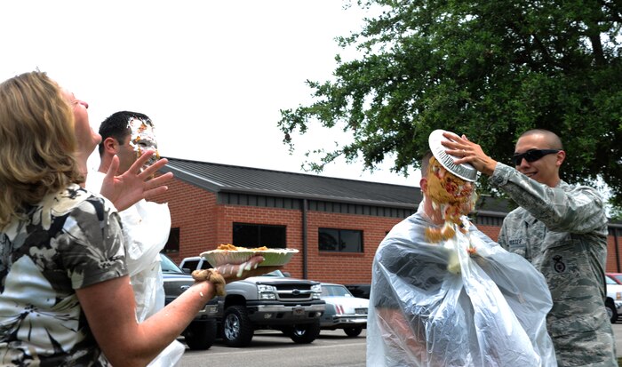 Senior Airman Matthew Baxter and Pamela Moss, 628th Security Forces Squadron, put a pie in the face of Master Sgt. Chad Hashley and Senior Master Sgt. Jason Heilman, May 16 at Joint Base Charleston - Air Base, S.C. For the Pie in the Face Contest, personnel from the 628th SFS placed money down toward who they wanted to be picked. The highest and the lowest number of votes were the chosen ones. The money raised for this event will go toward the Special Olympics in South Carolina. (U.S. Air Force photo/Airman 1st Class Ashlee Galloway)