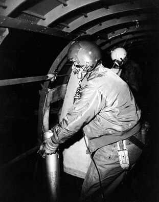 AC-47 crewmember preparing to throw a flare out of the open fuselage door. These flares helped expose enemy night attacks. (U.S. Air Force photo)