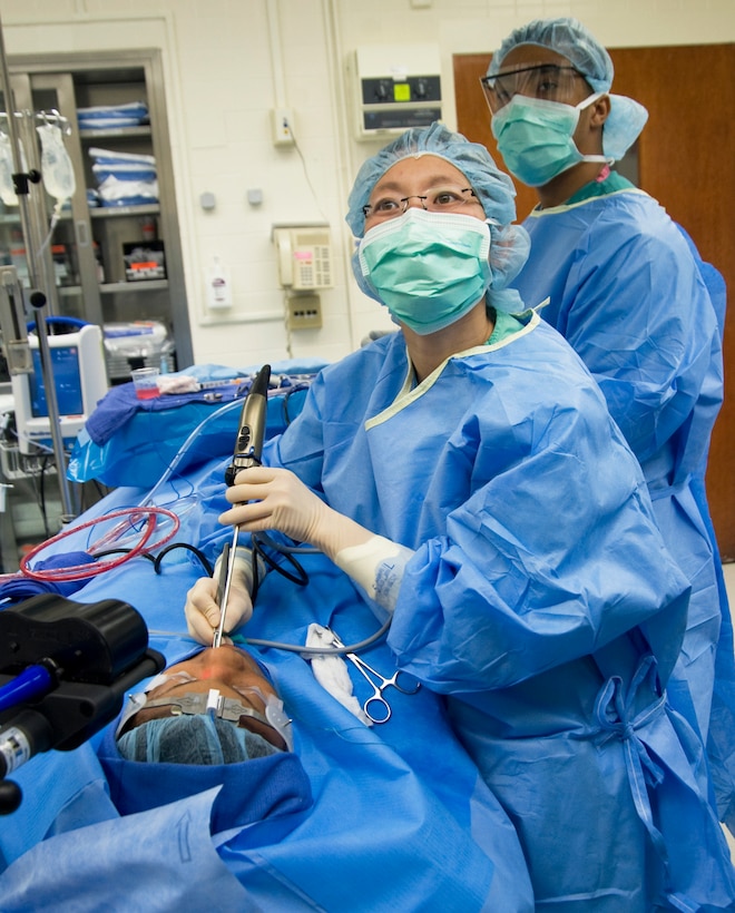 While viewing a monitor which assists her during endoscopic sinus surgery in real time, Dr. Carrie Flanagan, 779th Surgical Operations Squadron staff otolaryngologist uses an endoscope camera and Medtronic sinus shaver to perform an intricate ENT procedure May 11, 2012.   (Air Force photo/Bobby Jones) 