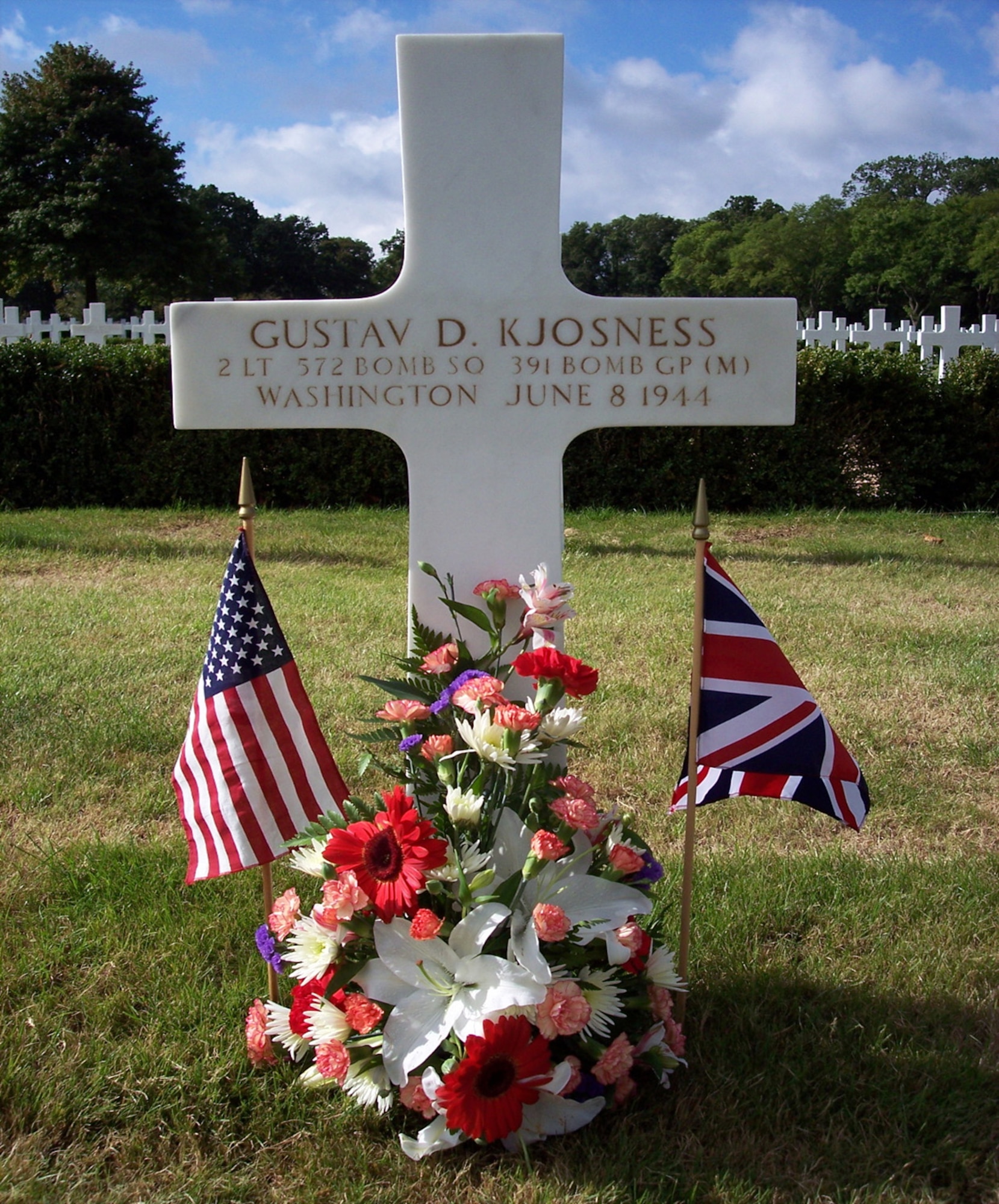 A photo of the Madingley American Cemetery (Cambridge, England) gravesite of 2nd Lt. Gustav D. Kjosness, 572nd Bomb Squadron, U.S. Army Air Forces, who was killed while performing a bombing mission against enemy ground targets June 6, 1944.  Kjosness, a B-26 Marauder bombardier, died while paving the success for the Normandy, France, landings, and was posthumously awarded the Distinguished Service Cross, the second highest award in the U.S. Army, equal to the Air Force Cross. (Courtesy photo)