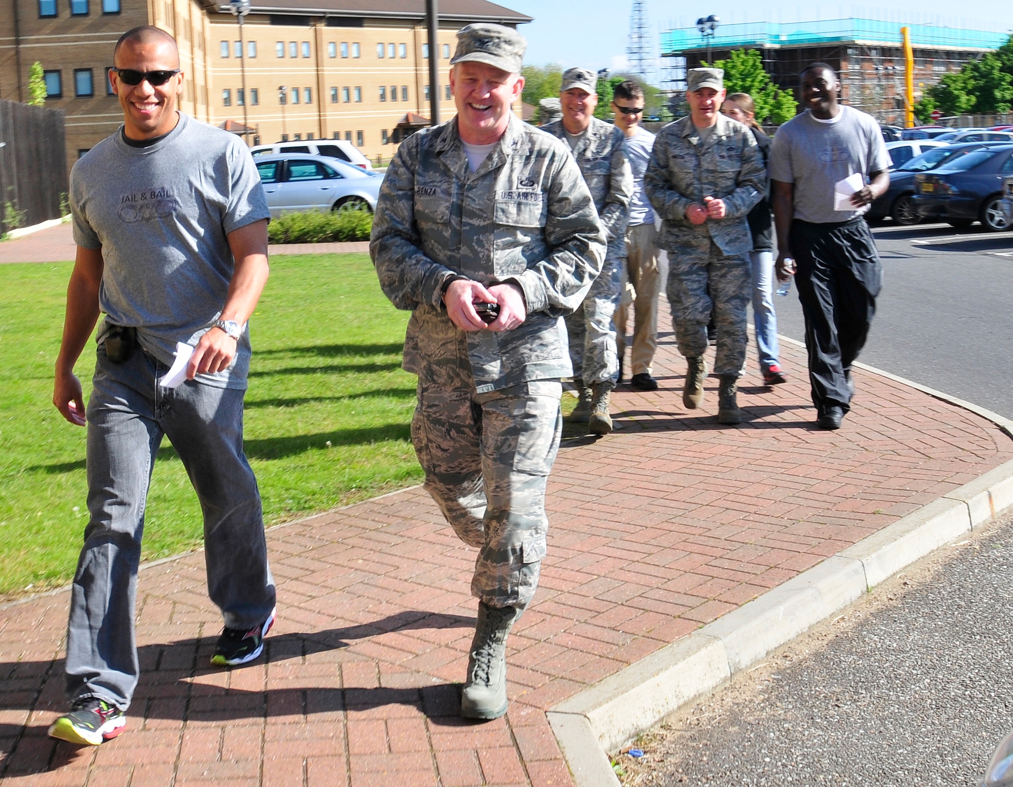 ROYAL AIR FORCE LAKENHEATH, England – Handcuffed Airmen and a civilian are escorted by 48th Security Forces Squadron members and others to the Base Exchange for ‘Jail & Bail’ May 16, 2012. To raise money for the 48th SFS Defender Council, people donated money to ‘lock up’ co-workers, spouses, friends and more for up to a maximum of four hours, at the cost of $10 per hour. To get out of jail early, inmates had to pay double what was paid to lock them up. (U.S. Air Force photo by Senior Airman Tiffany M. Deuel)