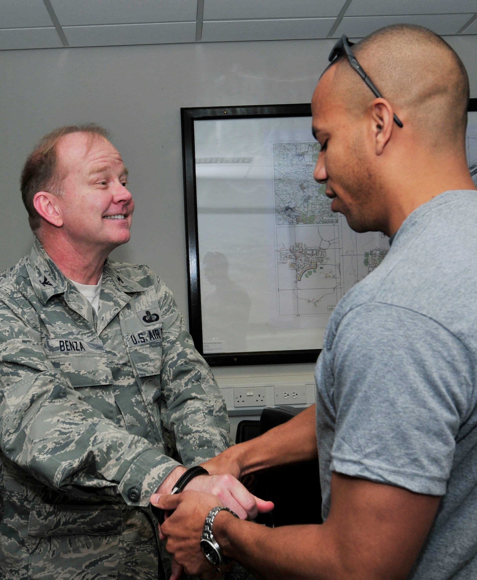 ROYAL AIR FORCE LAKENHEATH, England – Capt. Gil Wyche II, 48th Security Forces Squadron officer in charge of logistics and resources, handcuffs Col. Scott Benza, 48th Mission Support Group commander, during a meeting at the Liberty Center to take him to a mock jail at the Base Exchange for a ‘Jail & Bail’ fundraiser May 16, 2012. To raise money for the 48th SFS Defender Council, people donated money to ‘lock up’ co-workers, spouses, friends and more for up to a maximum of four hours, at the cost of $10 per hour. To get out of jail early, inmates had to pay double what was paid to lock them up. (U.S. Air Force photo by Senior Airman Tiffany M. Deuel)