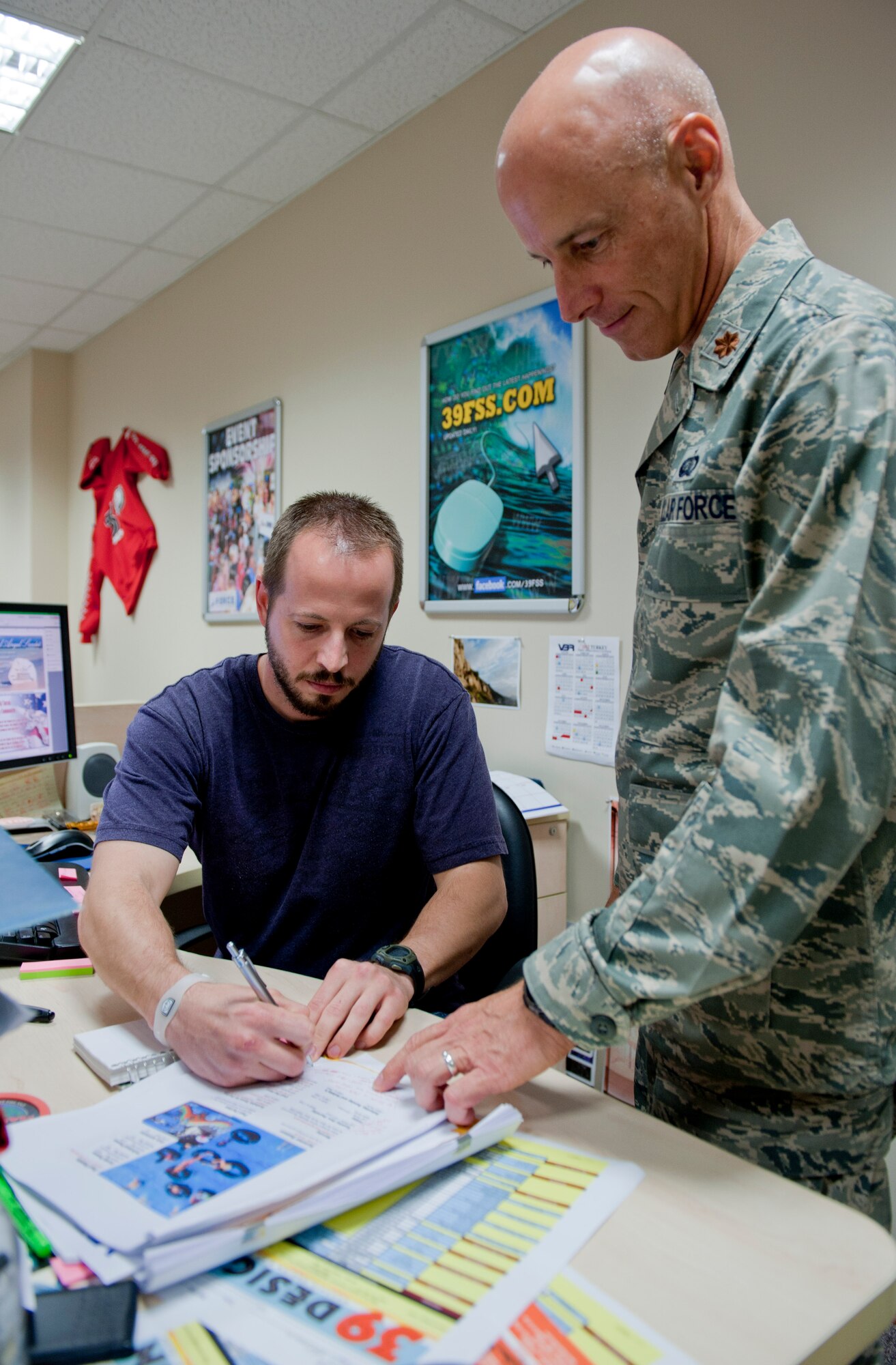Maj. Thomas Ausherman, 39th Force Support Squadron commander, right, reviews the next edition of the "Happenings" magazine with JT McKeen, 39th FSS graphic artist, May 16, 2012, at Incirlik Air Base, Turkey. As the commander, Ausherman oversees five flights including manpower, Airman and family services, community services, sustainment, and force development. (U.S. Air Force photo by Senior Airman Anthony Sanchelli/Released)
