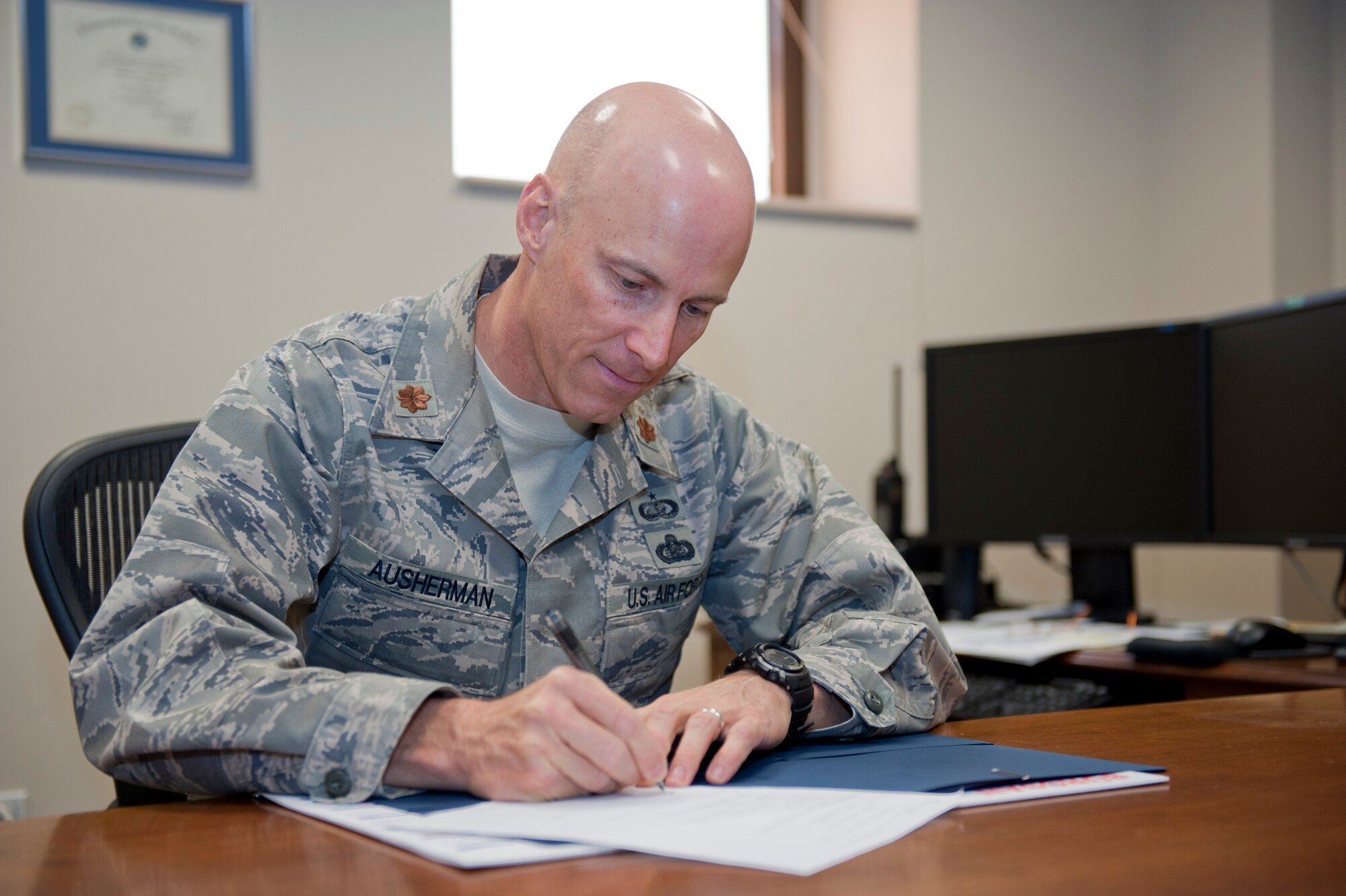 Maj. Thomas Ausherman, 39th Force Support Squadron commander, signs forms March 9, 2012, at Incirlik Air Base, Turkey. As the commander, Ausherman oversees five flights including manpower, Airman and family services, community services, sustainment, and force development. (U.S. Air Force photo by Senior Airman Anthony Sanchelli/Released)
