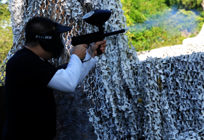 Airman 1st Class Joshua Cook, 628th Security Forces Squadron police officer, shoots a paintball during a match against defenders from the 628th Civil Engineer Squadron during the "Guns and Hoses" fitness challenge, May 15 at Joint Base Charleston - Air Base, S.C. The 628th SFS hosted the firefighters in a day full of competition known as the "Guns and Hoses" fitness challenge. The competitions included a paintball match, defender ball and a softball game. The event kicked off National Police Week, which occurs annually during the week of May 15. National Police Week recognizes the service and sacrifice of U.S. law enforcement personnel. (U.S. Air Force photo/Airman 1st Class Ashlee Galloway)