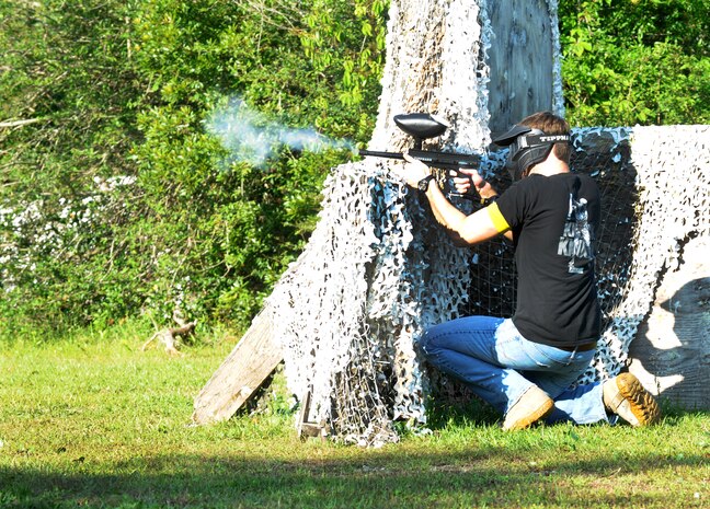 Staff Sgt. Kenneth Corbitt, 628th Security Forces Squadron police officer, shoots a paintball during a match against defenders from the 628th Civil Engineer Squadron during the "Guns and Hoses" fitness challenge, May 15 at Joint Base Charleston - Air Base, S.C. The 628th SFS hosted the firefighters in a day full of competition known as the "Guns and Hoses" fitness challenge. The competitions included a paintball match, defender ball and a softball game. The event kicked off National Police Week, which occurs annually during the week of May 15. National Police Week recognizes the service and sacrifice of U.S. law enforcement personnel. (U.S. Air Force photo/Airman 1st Class Ashlee Galloway)