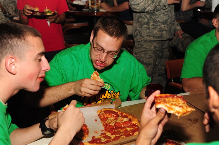 Volunteer firefighters compete in a pizza eating contest during the Grand Opening of Rookies Sports Grill at Joint Base Charleston May 11, 2012. Four teams of firefighters were given 10 minutes to eat all the pizza they could. (U.S. Air Force photo/Airman 1st Class Chacarra Walker)