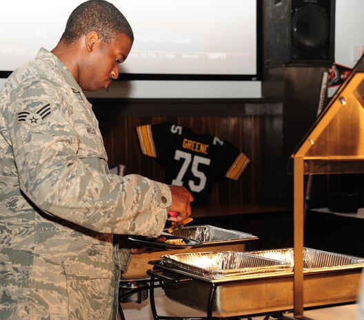 Senior Airman Adrian Welch, 437th Airlift Wing Aerospace Ground Equipment Apprentice journeyman, helps himself during the Grand Opening of Rookies Sports Grill Joint Base Charleston May 11, 2012. Rookies Sports Grill is a new spot on base for community members to enjoy great food while watching some of their favorite sports teams on the big screen. (U.S. Air Force photo/Airman 1st Class Chacarra Walker)