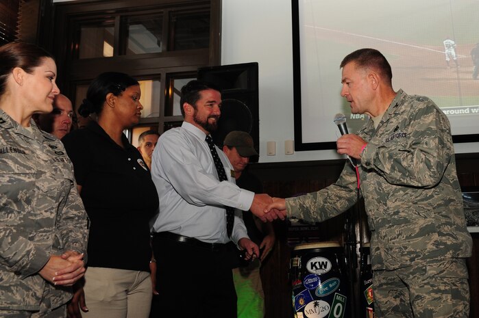 Col. Richard McComb, Joint Base Charleston commander, coins members of the 628th Force Support Squadron during the Grand Opening of Rookies Sports Grill May 11, 2012. Rookies Sports Grill is a new spot on base for community members to enjoy great food while watching some of their favorite sports teams on the big screen. (U.S. Air Force photo/Airman 1st Class Chacarra Walker)