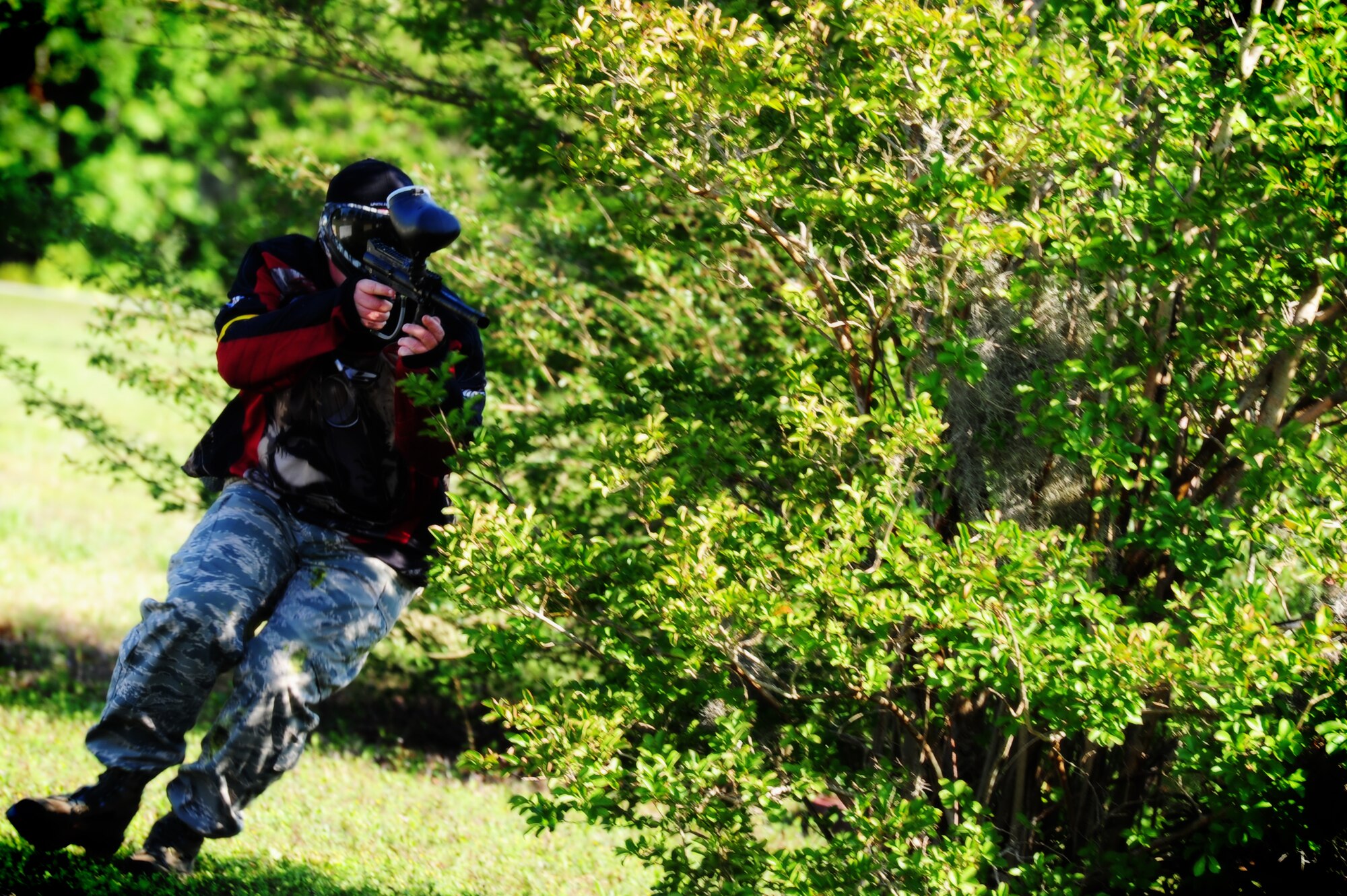 Tech Sgt. Brandon Neal, 628th Security Forces Squadron defender, takes cover behind a tree during a  paintball match against firefighters from the 628th Civil Engineer Squadron while competing in the "Guns and Hoses" fitness challenge, May 15 at Joint Base Charleston - Air Base, S.C.  The 628th SFS hosted the firefighters in a day full of competition known as the "Guns and Hoses" fitness challenge.  The competition included a paintball match, defender ball and a softball game.  The event kicked off National Police Week, which occurs annually during the week of May 15.  It recognizes the service and sacrifice of U.S. law enforcement personnel.  (U.S. Air Force photo, Staff Sgt. Nicole Mickle)  
 
