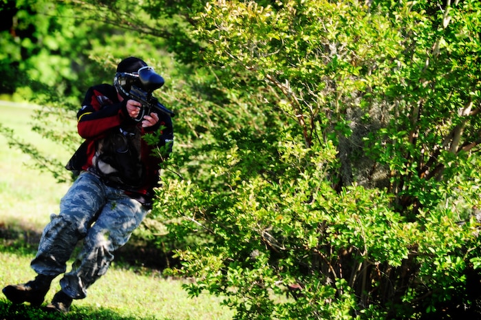 Tech Sgt. Brandon Neal, 628th Security Forces Squadron defender, takes cover behind a tree during a  paintball match against firefighters from the 628th Civil Engineer Squadron while competing in the "Guns and Hoses" fitness challenge, May 15 at Joint Base Charleston - Air Base, S.C.  The 628th SFS hosted the firefighters in a day full of competition known as the "Guns and Hoses" fitness challenge.  The competition included a paintball match, defender ball and a softball game.  The event kicked off National Police Week, which occurs annually during the week of May 15.  It recognizes the service and sacrifice of U.S. law enforcement personnel.  (U.S. Air Force photo, Staff Sgt. Nicole Mickle)  
 
