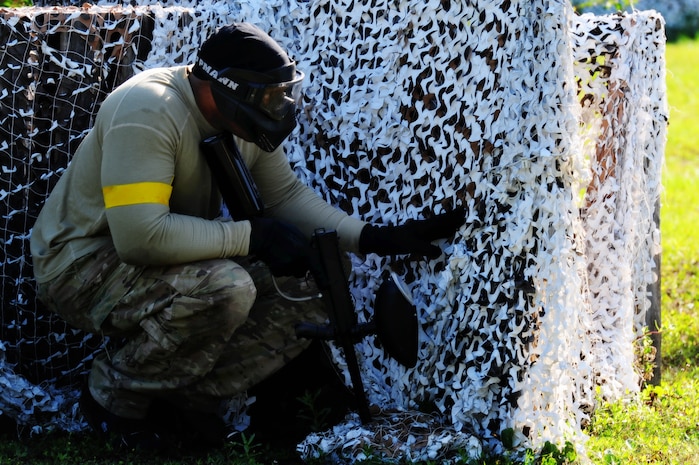 Staff Sgt. Ramon Alexander, 628th Security Forces Squadron defender, takes cover behind a barrier during a paintball match against firefighters from the 628th Civil Engineer Squadron firefighters while competing in the "Guns and Hoses" fitness challenge, May 15 at Joint Base Charleston - Air Base, S.C.  The 628th SFS hosted the firefighters in a day full of competition known as the "Guns and Hoses" fitness challenge.  The competitions included a paintball match, defender ball and a softball game.  The event kicked off National Police Week, which occurs annually during the week of May 15.  It recognizes the service and sacrifice of U.S. law enforcement personnel.  (U.S. Air Force photo/ Staff Sgt. Nicole Mickle)  