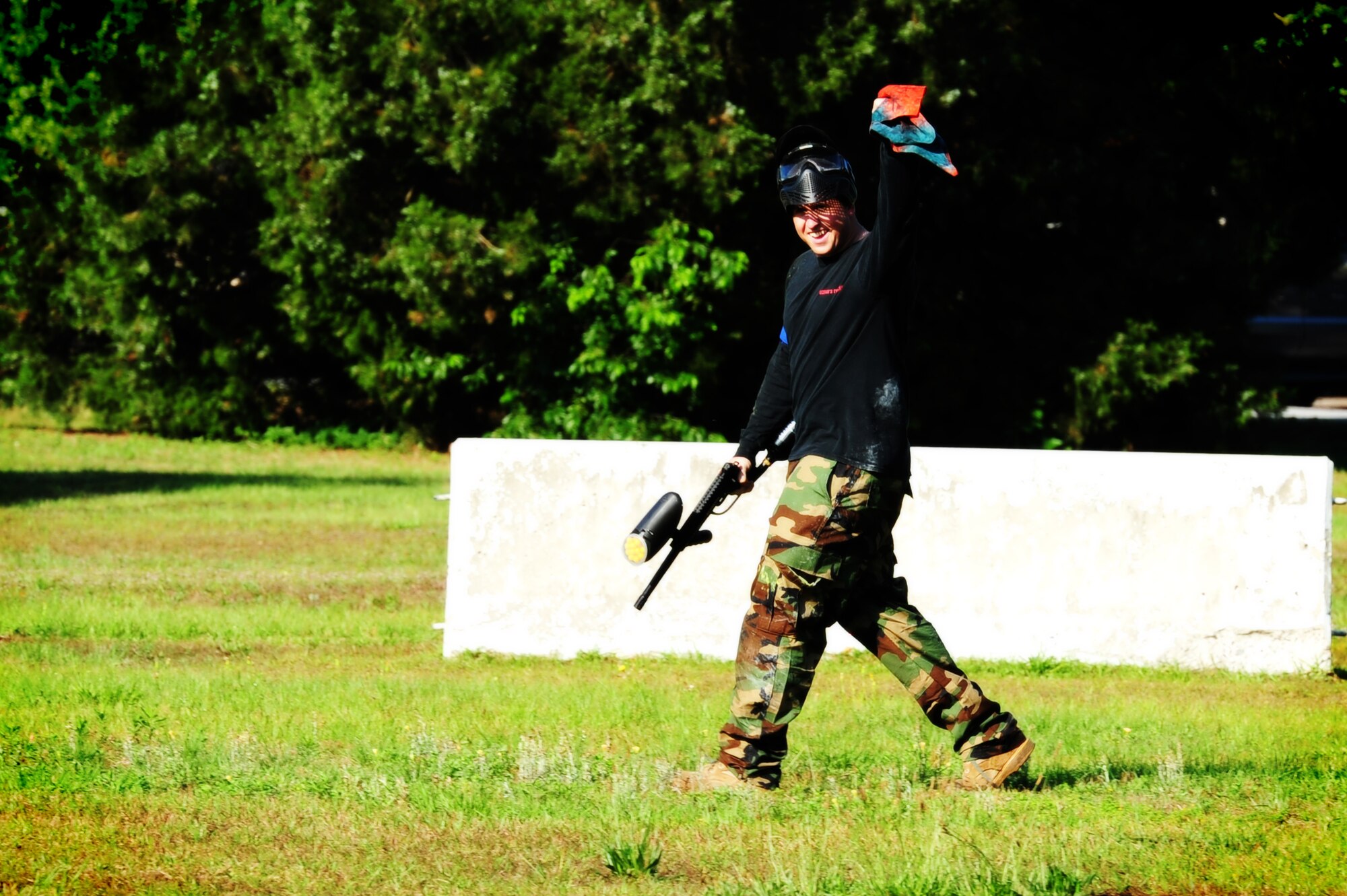 Staff Sgt. Kyle Rose, 628th Civil Engineer Squadron firefighter, waves the flag after capturing it during a paintball match against defenders from the 628th Security Forces Squadron while competing in the "Guns and Hoses" fitness challenge, May 15 at Joint Base Charleston - Air Base, S.C.  The 628th SFS hosted the firefighters in a day full of competition known as the "Guns and Hoses" fitness challenge.  The competition included a paintball match, defender ball and a softball game.  The event kicked off National Police Week, which occurs annually during the week of May 15.  It recognizes the service and sacrifice of U.S. law enforcement personnel.  (U.S. Air Force photo/ Staff Sgt. Nicole Mickle)  