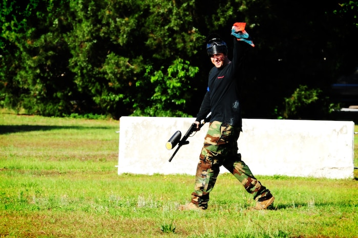 Staff Sgt. Kyle Rose, 628th Civil Engineer Squadron firefighter, waves the flag after capturing it during a paintball match against defenders from the 628th Security Forces Squadron while competing in the "Guns and Hoses" fitness challenge, May 15 at Joint Base Charleston - Air Base, S.C.  The 628th SFS hosted the firefighters in a day full of competition known as the "Guns and Hoses" fitness challenge.  The competition included a paintball match, defender ball and a softball game.  The event kicked off National Police Week, which occurs annually during the week of May 15.  It recognizes the service and sacrifice of U.S. law enforcement personnel.  (U.S. Air Force photo/ Staff Sgt. Nicole Mickle)  