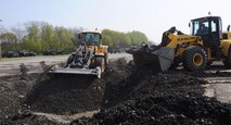 U.S. Airmen with the 35th Civil Engineer Squadron pushes dirt into a man-made crater during the squadron’s training exercise at Misawa Air Base, Japan, May 17, 2012. The crater was dug in the middle of a large concrete slab and served as a realistic representation of what the flightline may look like after impacted by a bomb. The training exercise ensures 35 CES Airmen understand the process for repairing flightline damages. (U.S. Air Force photo by Airman Kenna Jackson/Released)